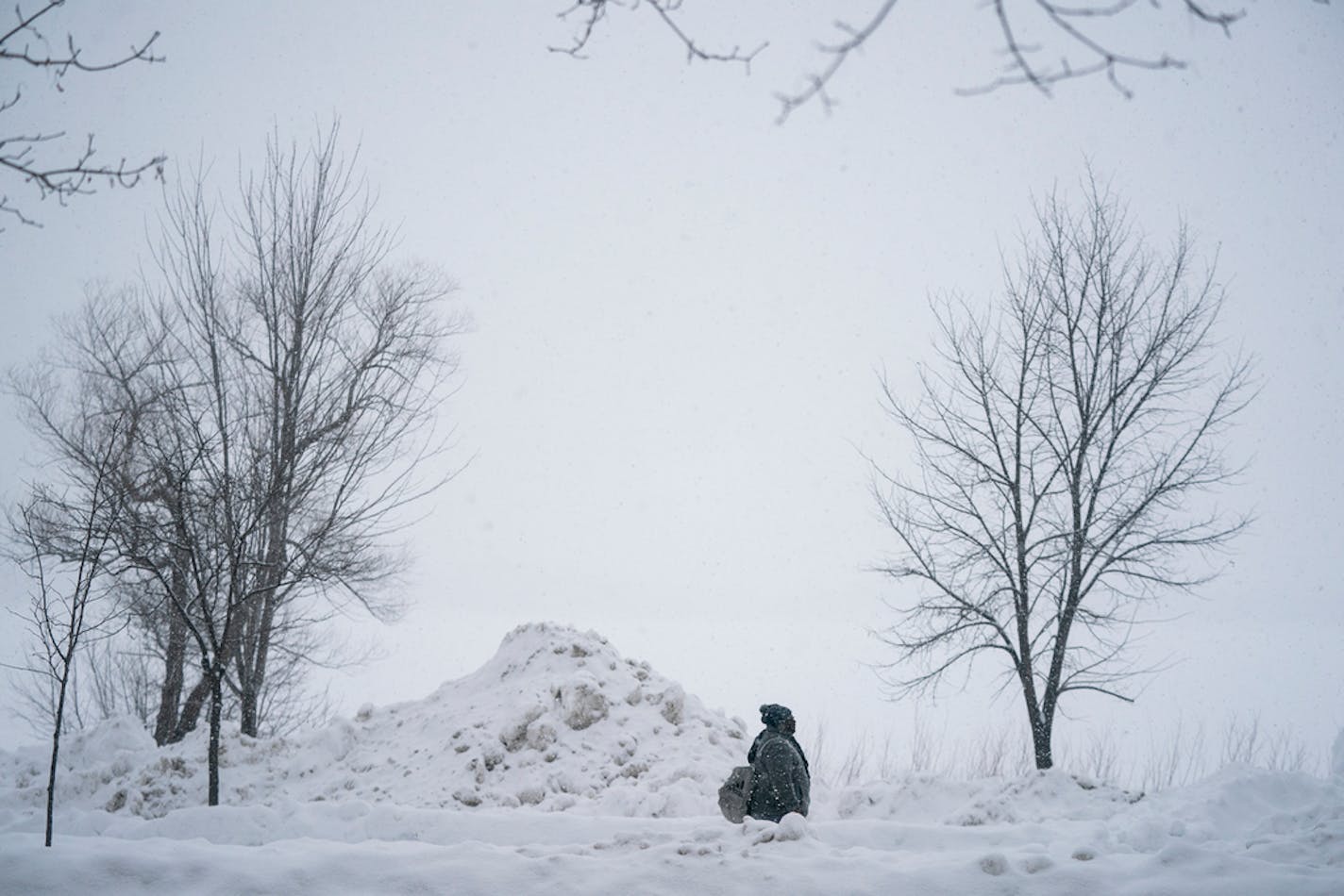 A pile of plowed snow dwarfs a pedestrian Friday, March 1, 2019, along Bde Maka Ska (formerly Lake Calhoun) in Minneapolis. BACKGROUND INFORMATION: Cool School Plunge + Super Plunge, part of the Minneapolis Polar Plunge's Frozen Friday events at Thomas Beach on Bde Maka Ska in Minneapolis on Friday, March 1, 2019. Snow accumulating 2-4 inches is predicted for the first day of March, followed by cold temperatures.