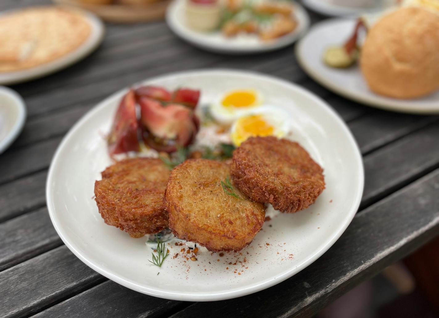 Cardamom's latkes with egg, heirloom tomatoes and yogurt sauce on the patio outside Walker Art Center.