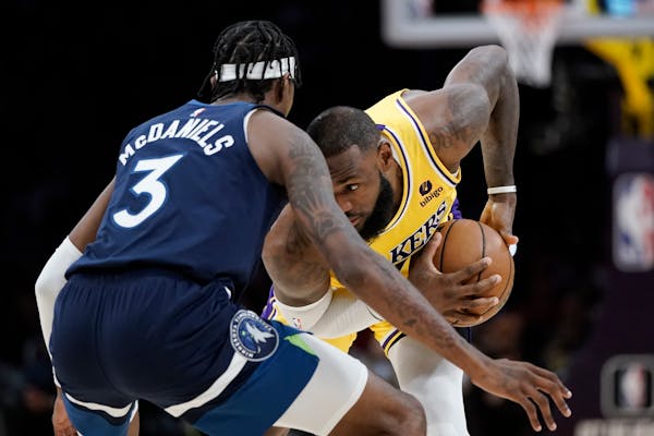 Los Angeles Lakers' LeBron James is pressured by Minnesota Timberwolves' Jaden McDaniels during first half of an NBA preseason basketball game Wednesd