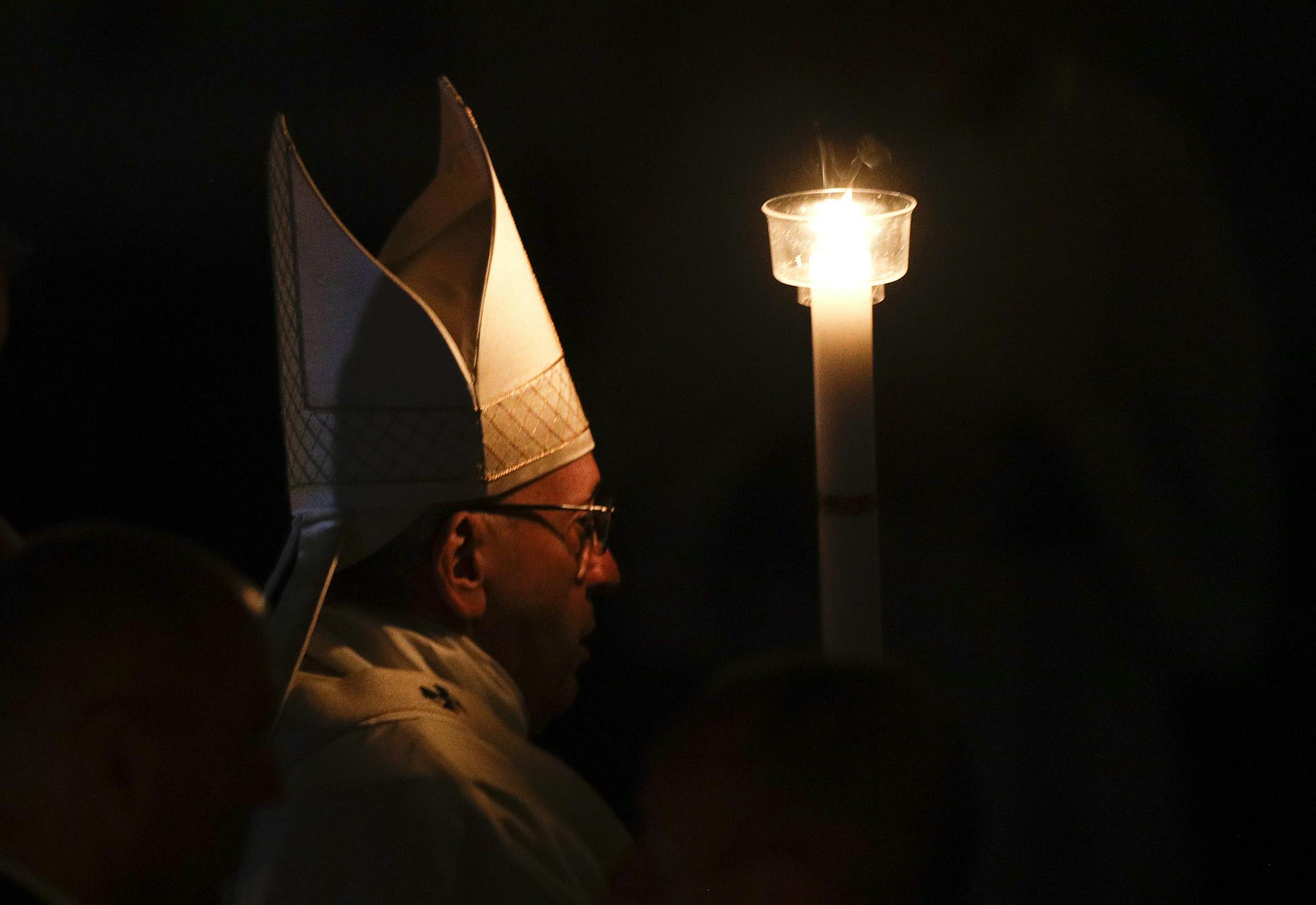 Pope Francis holds a candle as he presides over a solemn Easter vigil ceremony in St. Peter's Basilica at the Vatican, Saturday, March 31, 2018. (AP Photo/Gregorio Borgia)