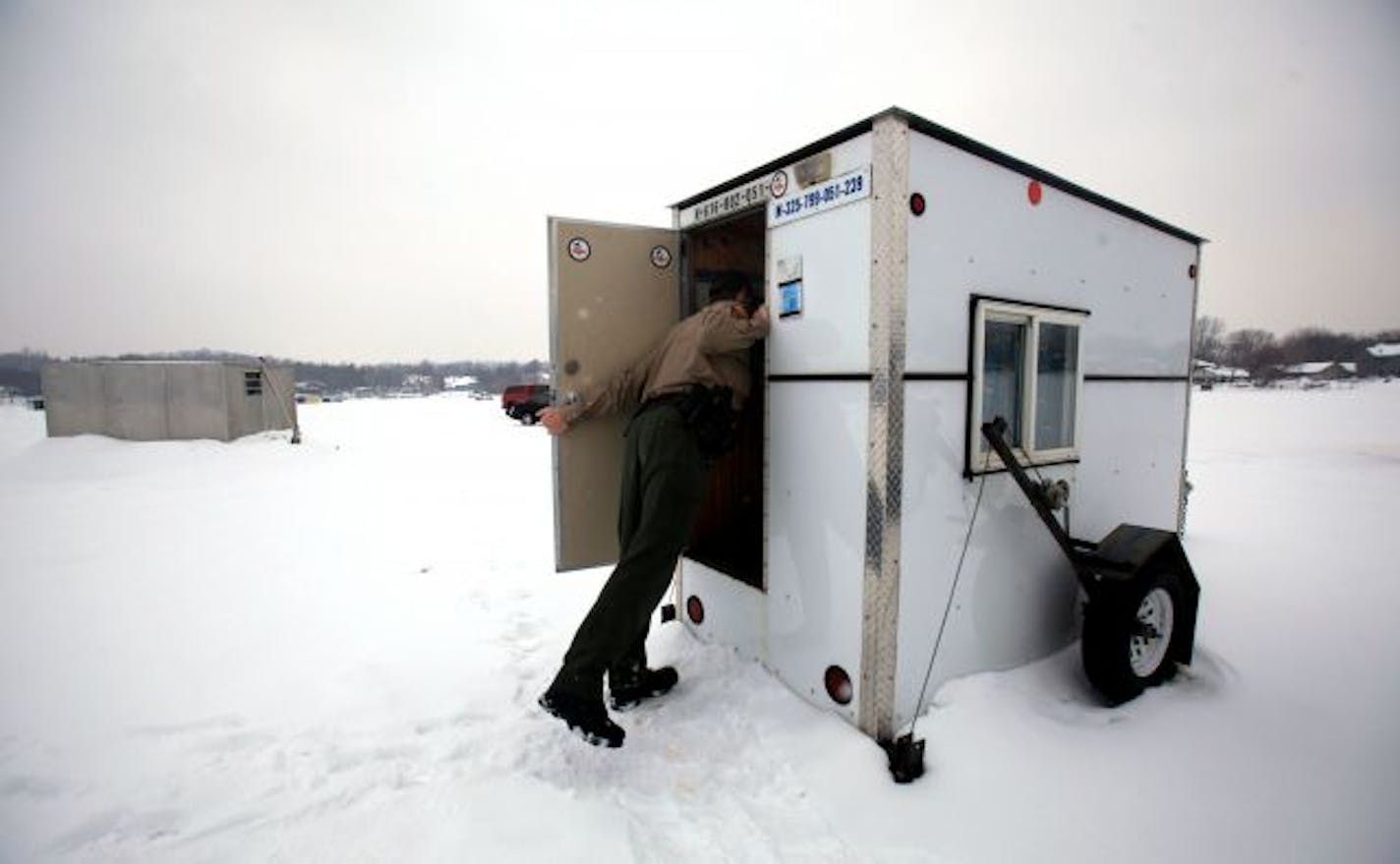 DNR conservation officer Adam Block leaned in the doorway of an angler's ice house on Prior Lake after knocking and getting permission to enter. A 2002 state Supreme Court ruling required officers to get permission before entering a fish house.