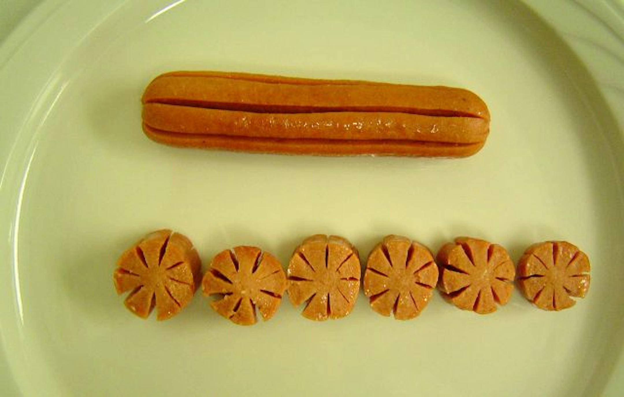 The Kinder Cut Hot Dog is a patented cutting design, which reduces the likelihood of choking. The hotdog has 8 lengthwise slits leaving a core. By cutting the hotdog into 11 pieces and using any method to cook, the slits open up into a starburst design.