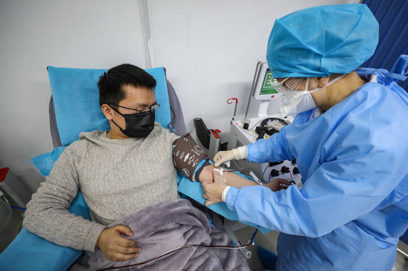 This photo taken on February 18, 2020 shows a doctor, left, who has recovered from the COVID-19 coronavirus infection donating plasma in Wuhan, China. (AFP/Getty Images/TNS) ORG XMIT: 1613001