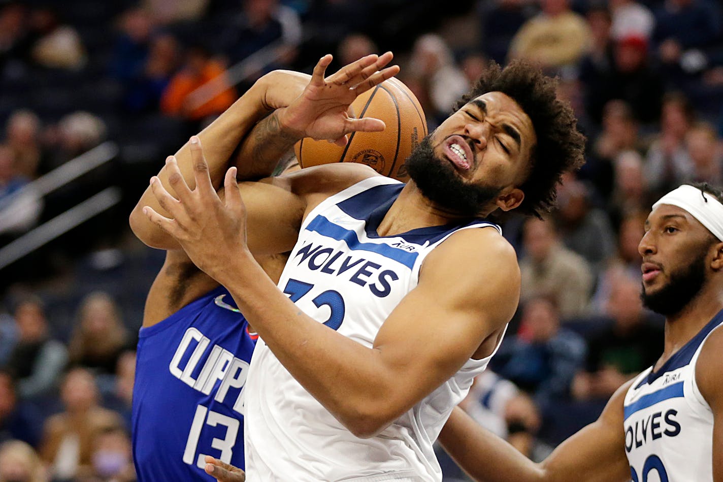 Minnesota Timberwolves center Karl-Anthony Towns (32) is fouled by Los Angeles Clippers guard Paul George (13) during the first half of an NBA basketball game Wednesday, Nov. 3, 2021, in Minneapolis. (AP Photo/Andy Clayton-King)