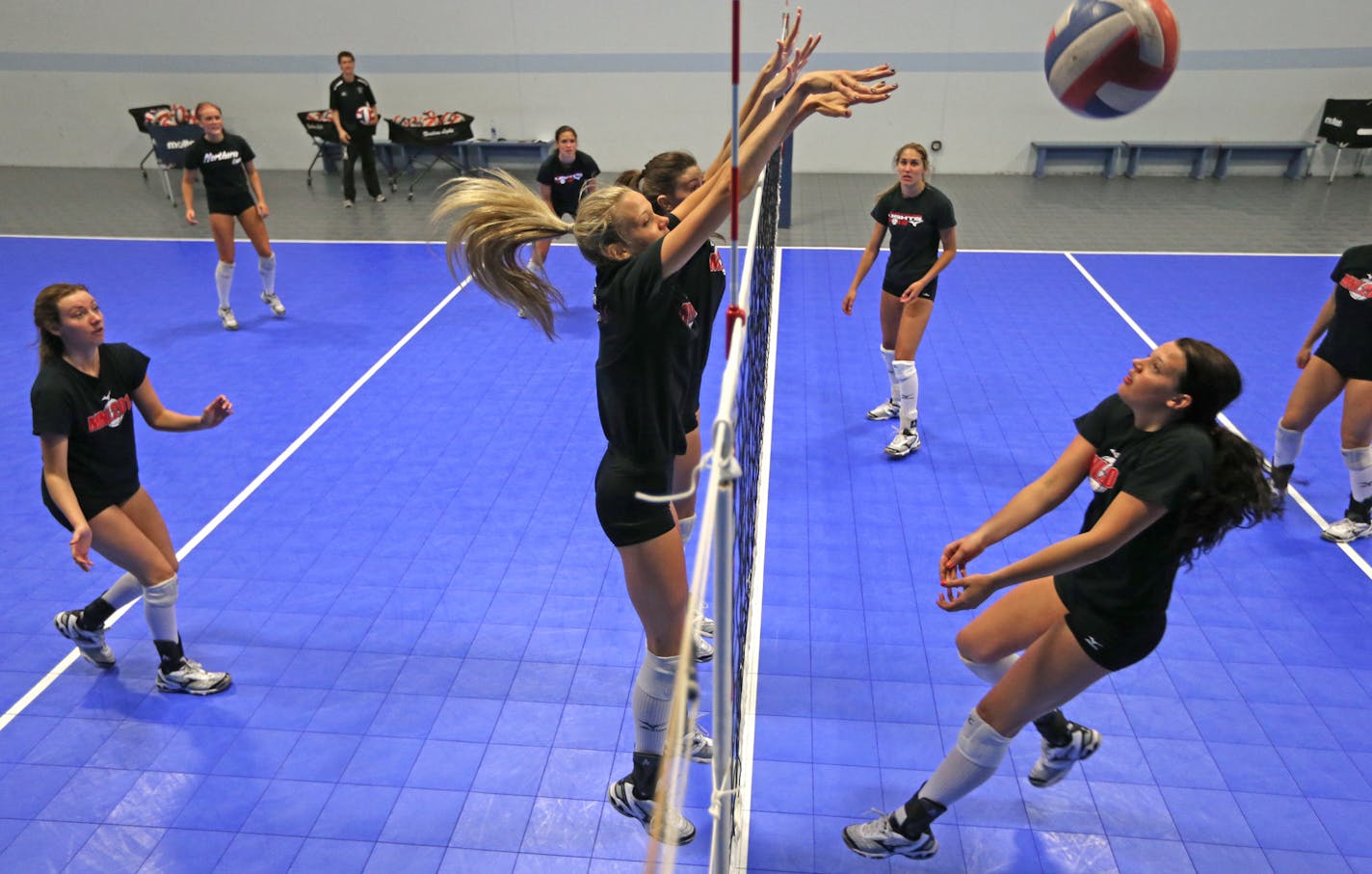 Paige Tapp, center right, and Nora Reed, center left, combined for a double block during a Northern Lights 18-1 practice. The unusually close team of elite players will compete for an AAU national title this week.