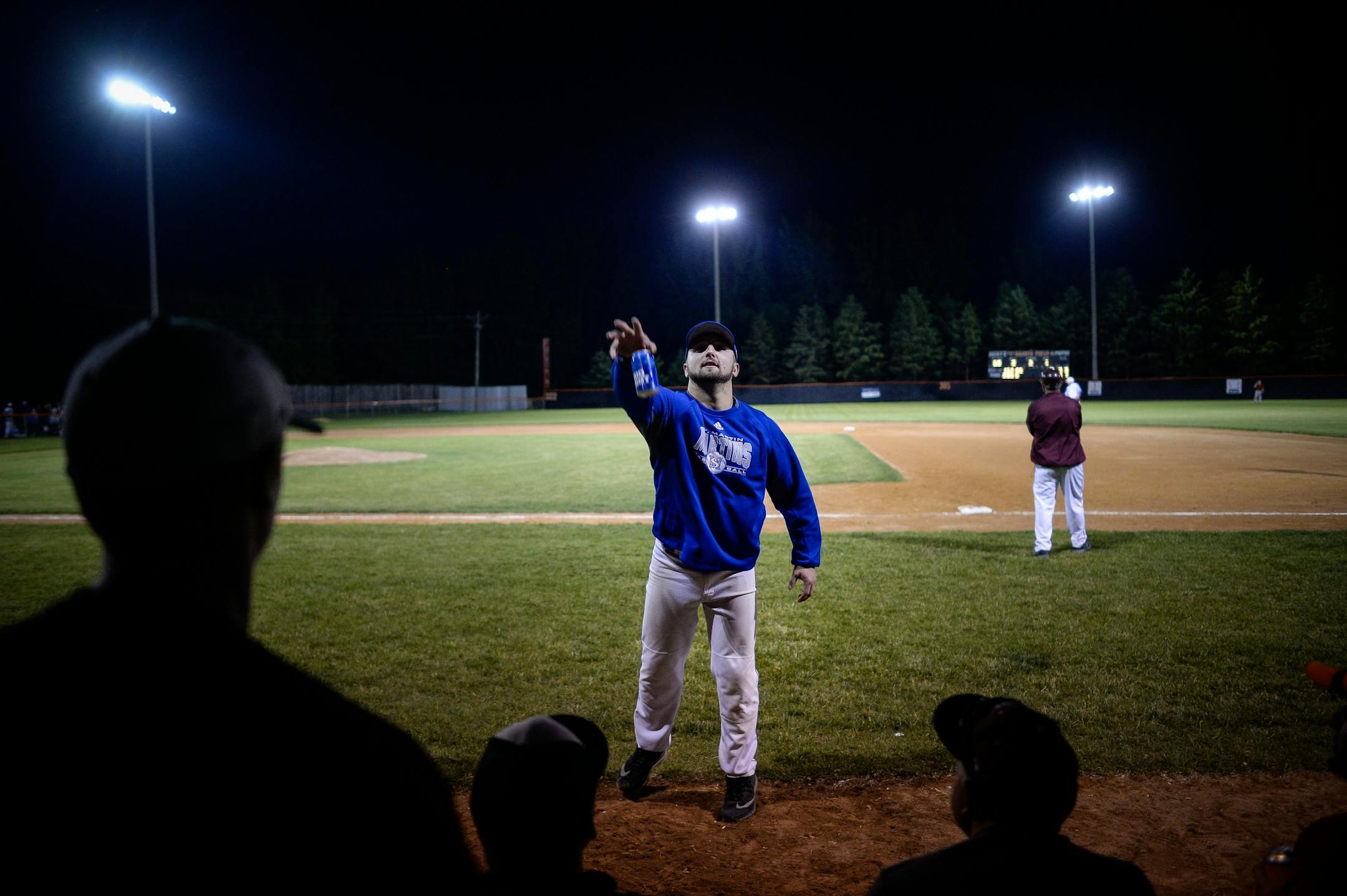 St. Martin outfielder Taylor Holthaus tossed a beer on top of the dugout that was thrown onto the field by a fan during the all-star game between the County Line League and the Stearns County League on Friday, June 30, 2017 in Elrosa, Minn. Beer-drinking fans have made a game out of tossing their beers onto the dugout, with contestants trying to toss their beer as close to the edge of the dugout as possible, with many going over near the field of play.