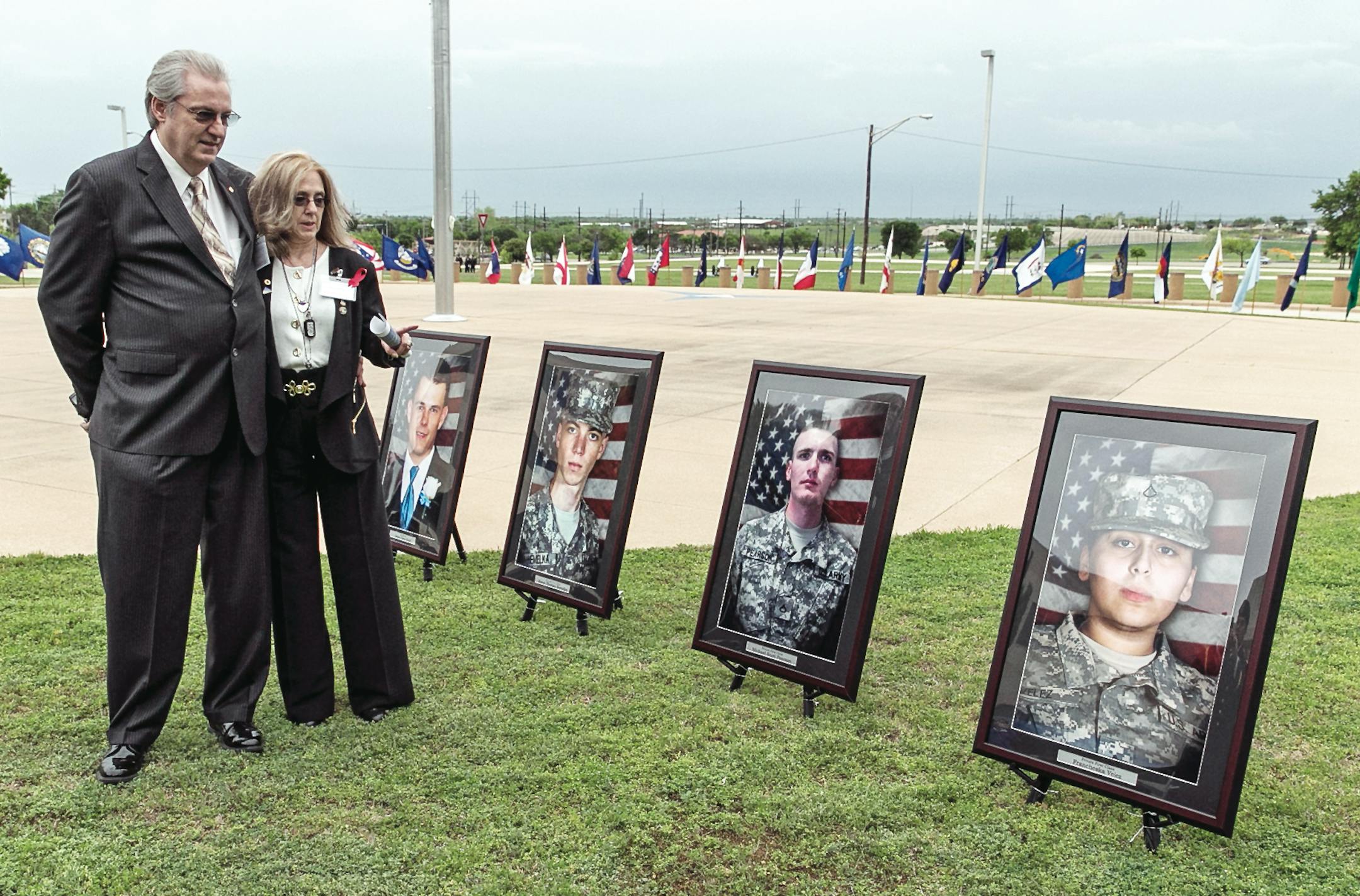 Jeffrey and Sheryll Pearson, parents of Pfc. Michael Pearson, second picture from right, who was killed during the attack by Maj. Nidal Hasan in the 2009 Fort Hood shooting, visit in front of his picture prior to a Purple Heart ceremony held at Fort Hood, Texas, Friday, April 10, 2015. Survivors and family members of those killed during the attack were awarded medals: a Purple Heart for soldiers and Defense of Freedom Medals for civilians. (AP Photo/Austin American-Statesman, Rodolfo Gonzalez, P