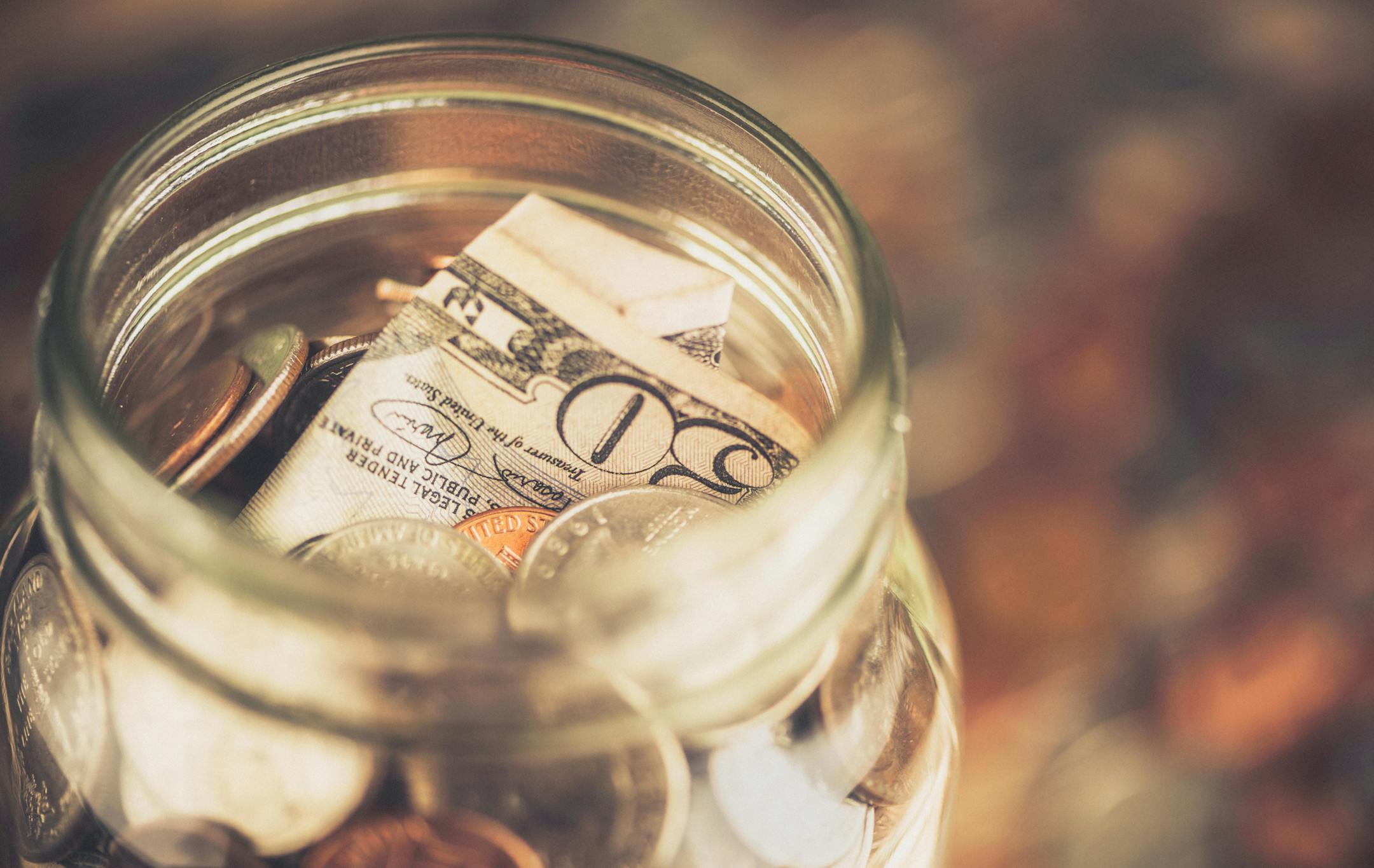 Generous Donation: Fifty Dollar Bill in Donation Jar. istock