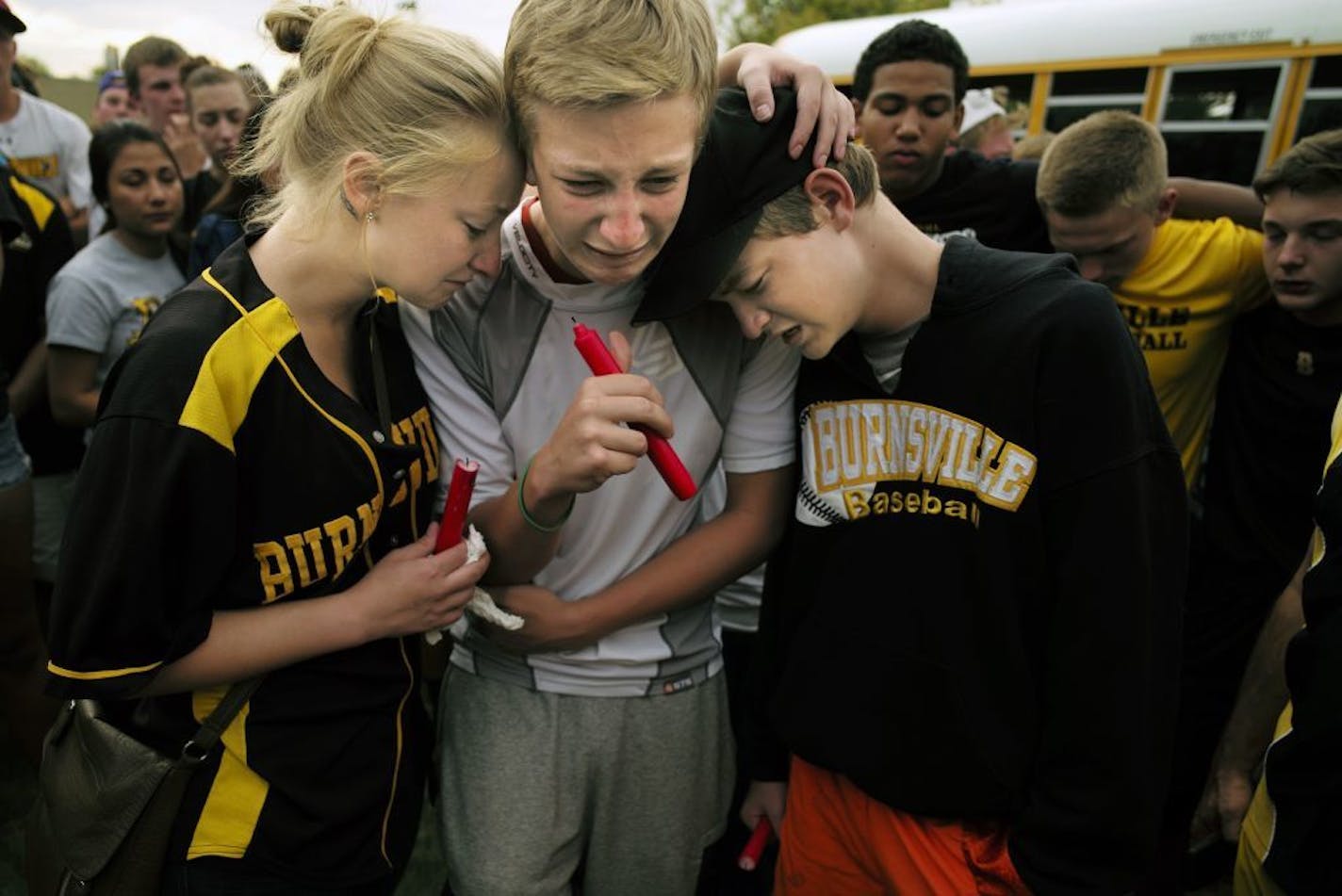 On a sport field at Burnsville H.S. on July 7, 2014, sibilings Cassie, Drew, and Trace Alyea grieved for the loss of their sibling Ty at a vigil where Burnsville students gathered to lend their support.