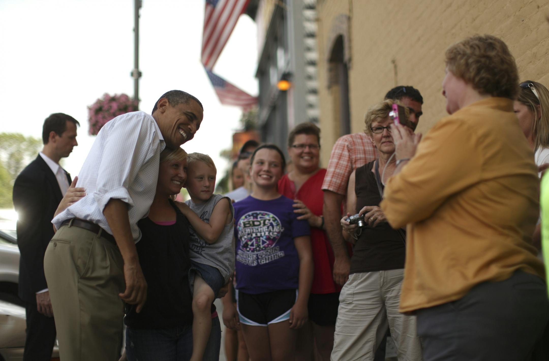 President Barack Obama poses for a photo with people gathered outside the Old Market Deli in Cannon Falls, where he stopped for lunch after a town meeting on Monday.