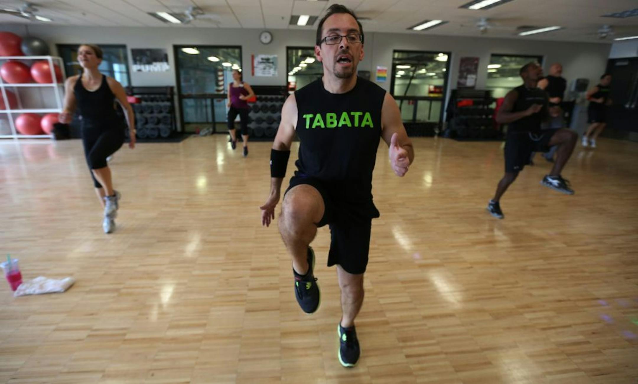 Instructor Rick Santiago goes through a series of exercises during a Tabata workout at the Andover YMCA.