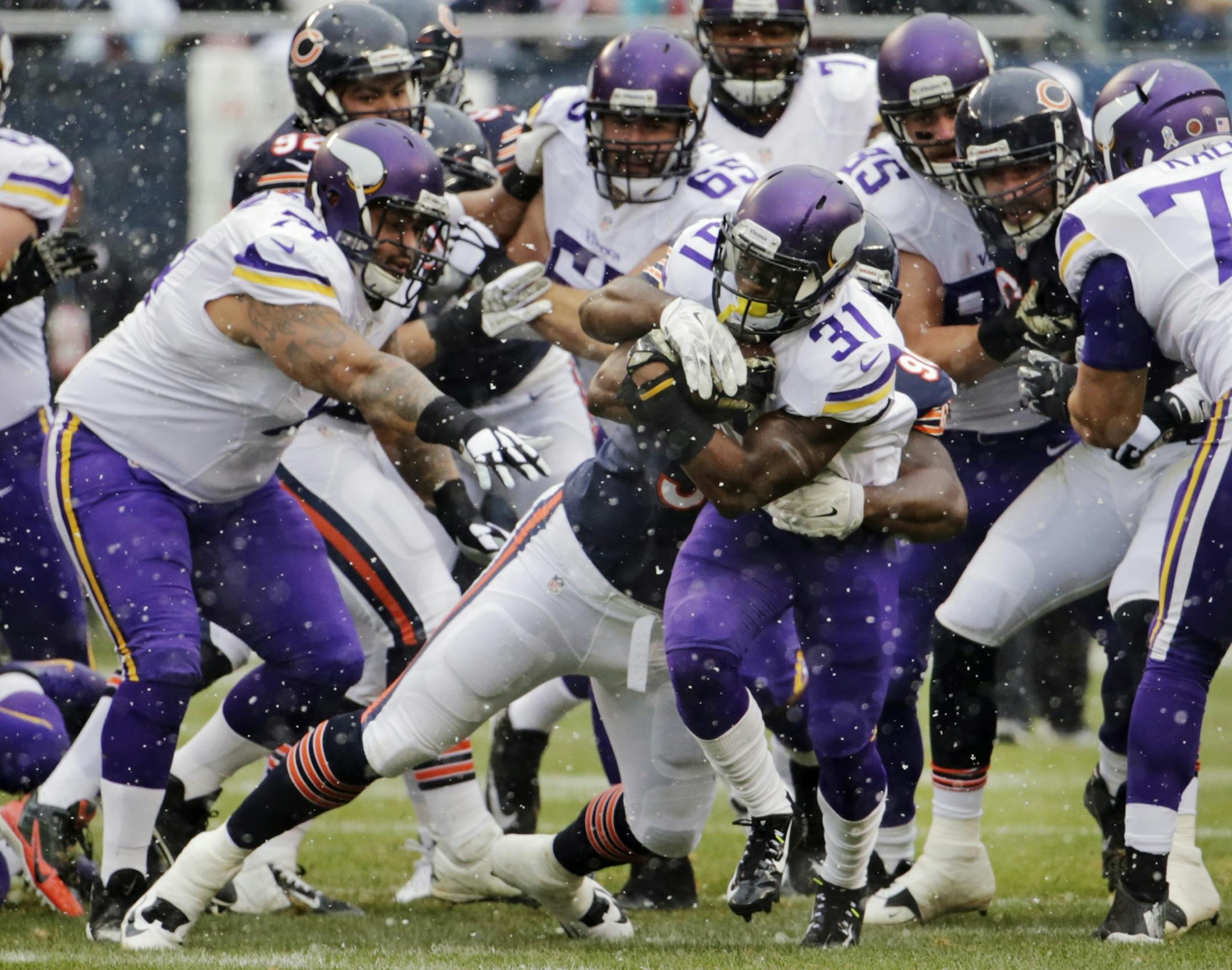 Minnesota Vikings running back Jerick McKinnon (31) is tackled by Chicago Bears defensive tackle Jeremiah Ratliff during the first half of an NFL football game Sunday, Nov. 16, 2014 in Chicago.