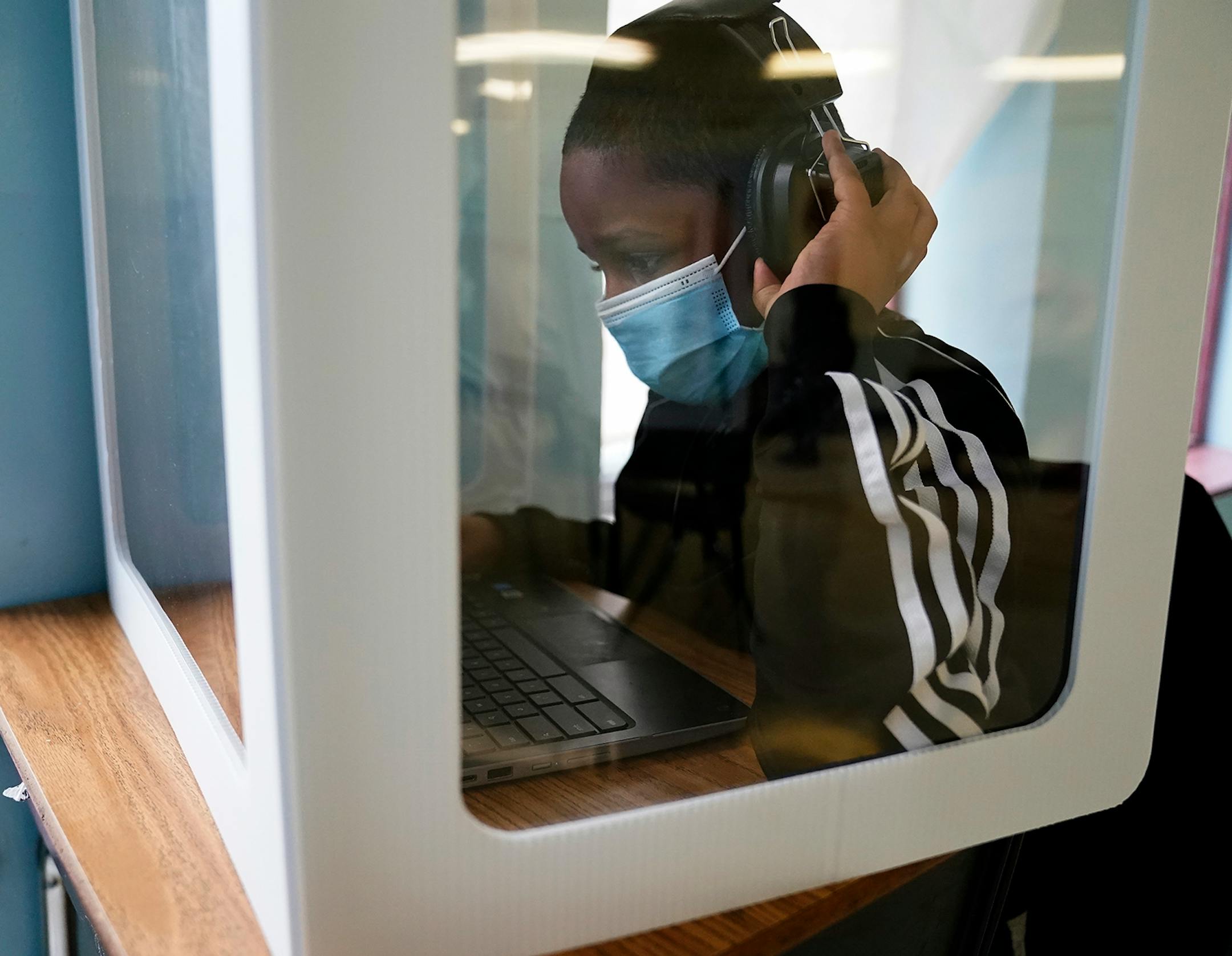 It was back to school for some students at Harvest Best Academy Tuesday in Minneapolis, but with masks, plastic barriers and other new precautions in the era of COVID-19. Here, a Harvest Best Academy student surrounded by a protective plexiglass barrier in a pod of students in 1st through 6th grades.
