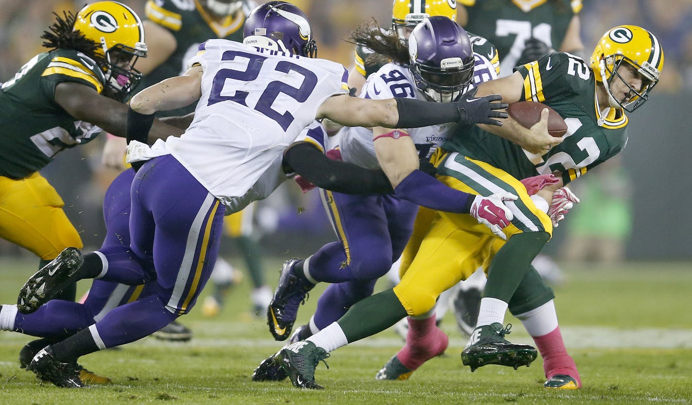 Packers quarterback Aaron Rodgers(12) evaded Harrison Smith (22) and Brian Robison (96) in the second quarter. Rodgers was eventually tackled by Sharrif Floyd on the play. ] CARLOS GONZALEZ cgonzalez@startribune.com - October 2, 2014 , Green Bay, WI NFL, Lambeau Field, Minnesota Vikings vs. Green Bay Packers