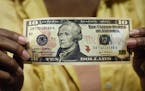 FILE - In this March 2, 2006 file photo, a $10 bill, featuring a likeness of Andrew Hamilton, the first U.S. Treasury secretary, is displayed at the N