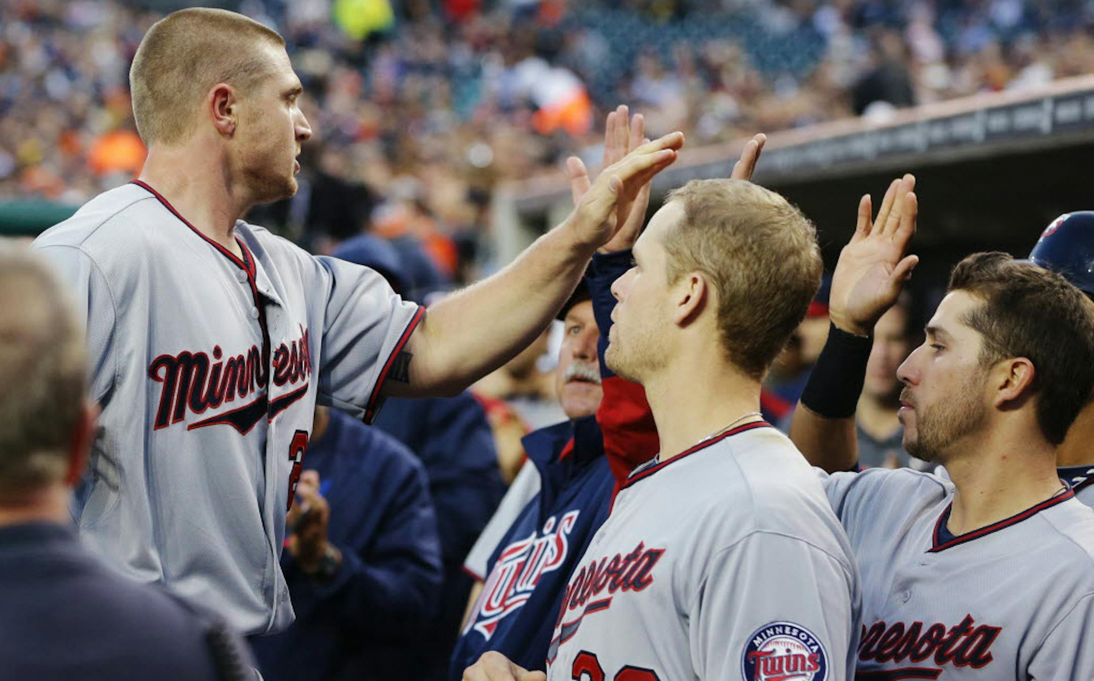 Minnesota's Chris Parmelee, left, is met in the dugout after scoring from second on a double by Oswaldo Arcia during the fourth inning on Monday.