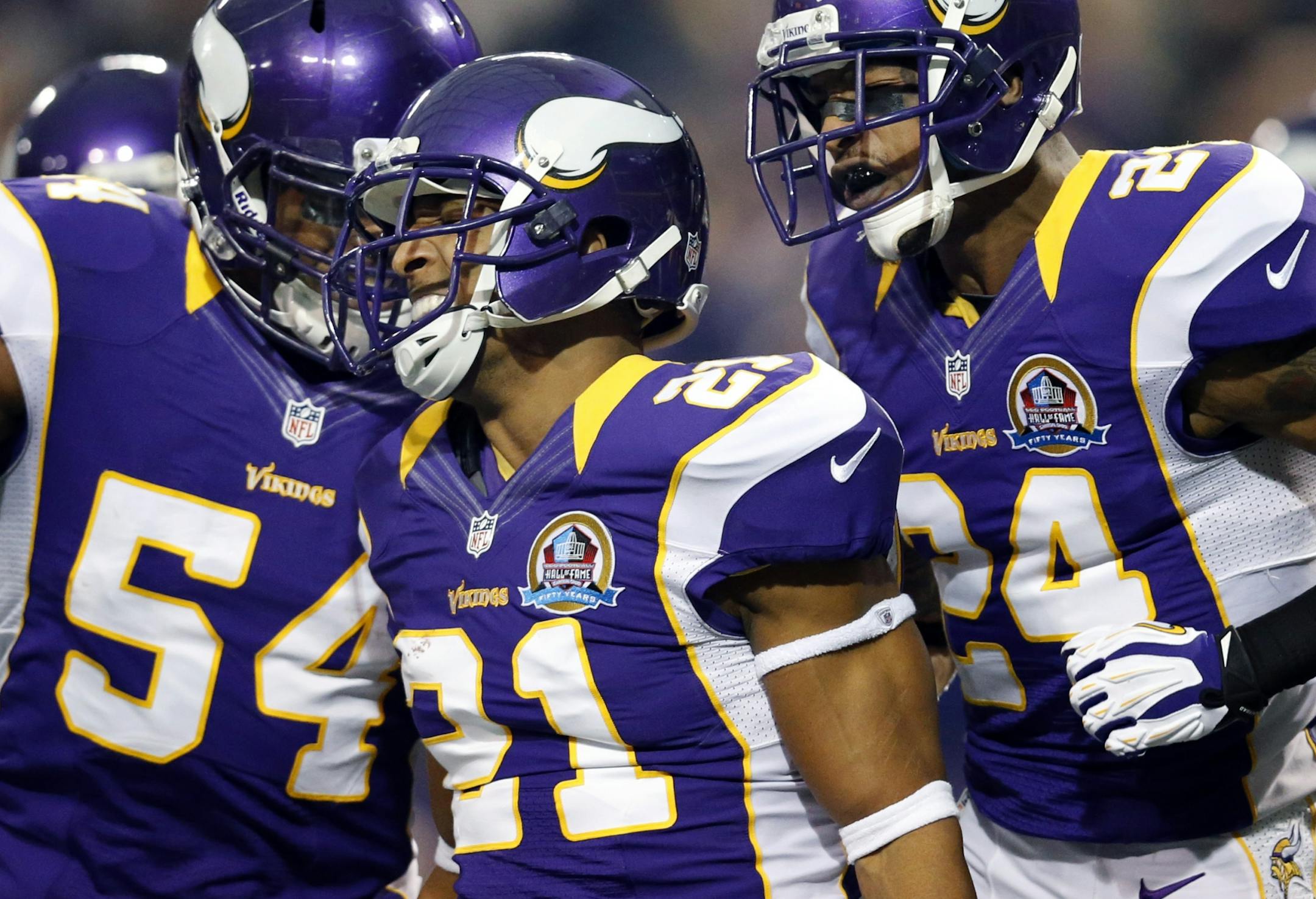 Josh Robinson (21) celebrated with Jasper Brinkley (54) and A.J. Jefferson (24) after Robinson intercepted a Jay Cutler pass in the first quarter.