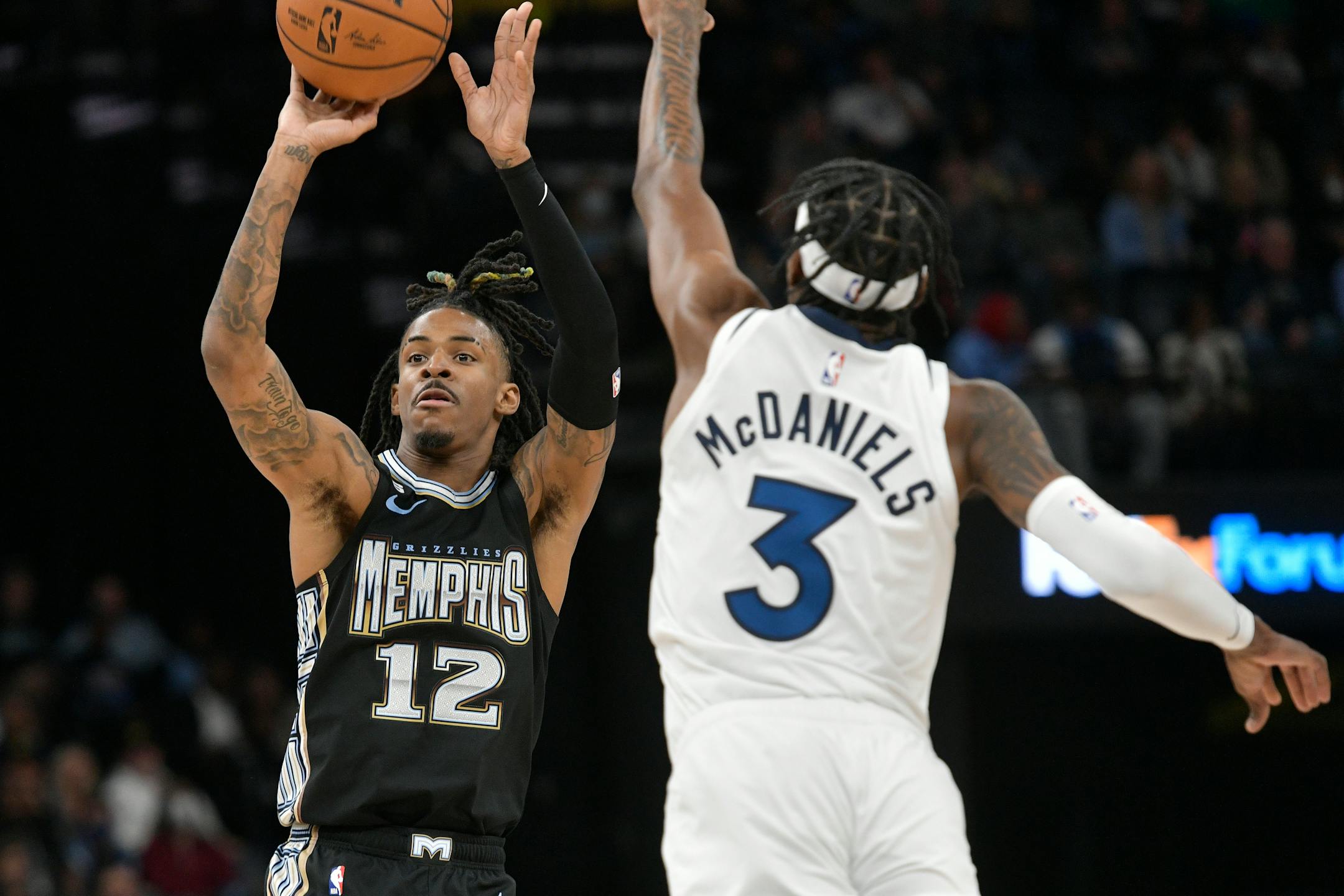 Grizzlies guard Ja Morant shoots against Timberwolves forward Jaden McDaniels during the second half Friday night.