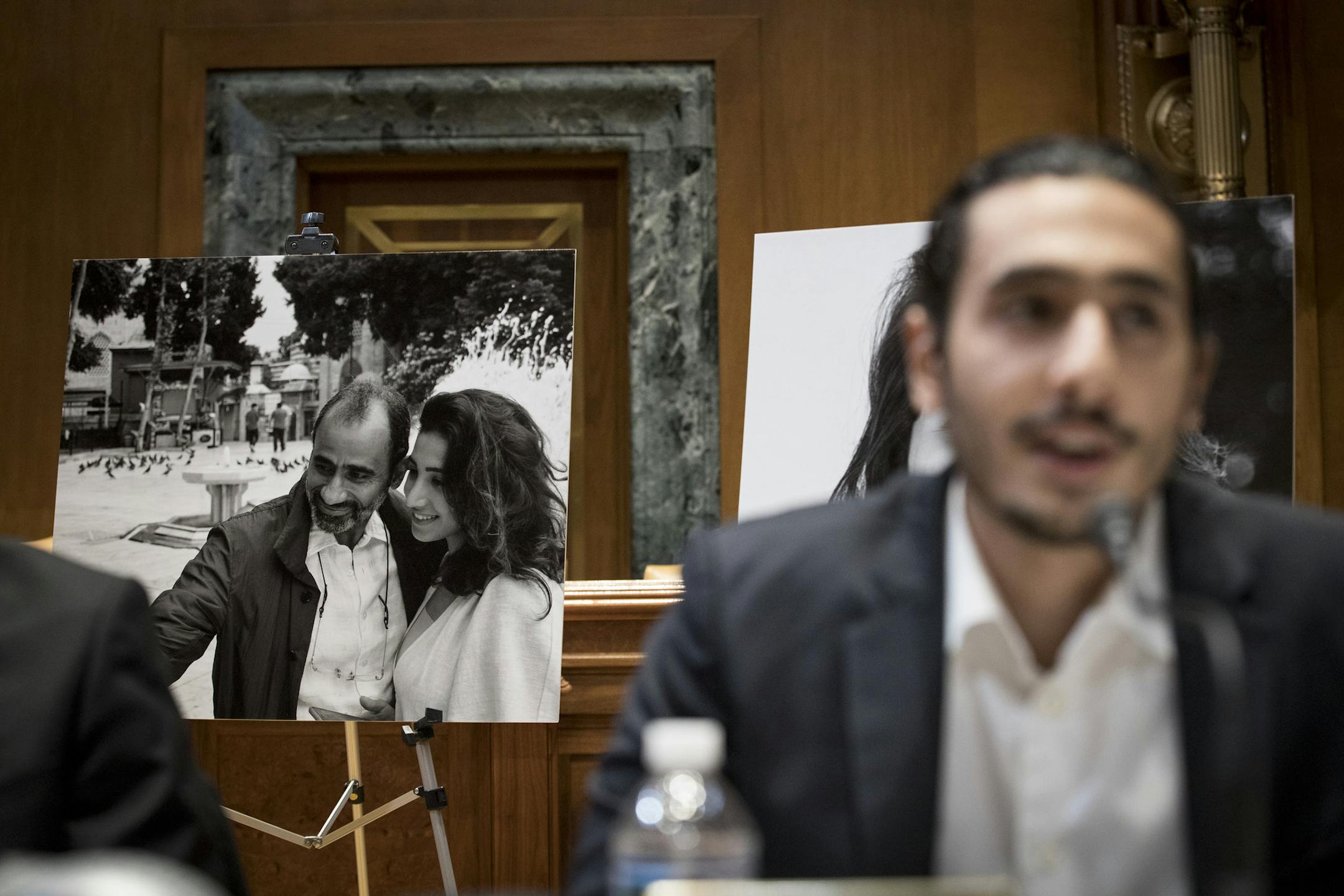 A photograph of Dr. Walid Fitaihi behind his son, Ahmad, during a news conference in Washington on March 14, 2019.
