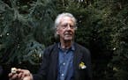 Austrian author Peter Handke holds a mushroom that he picked during a walk near his house as he poses for a photo in Chaville near Paris, Thursday, Oc