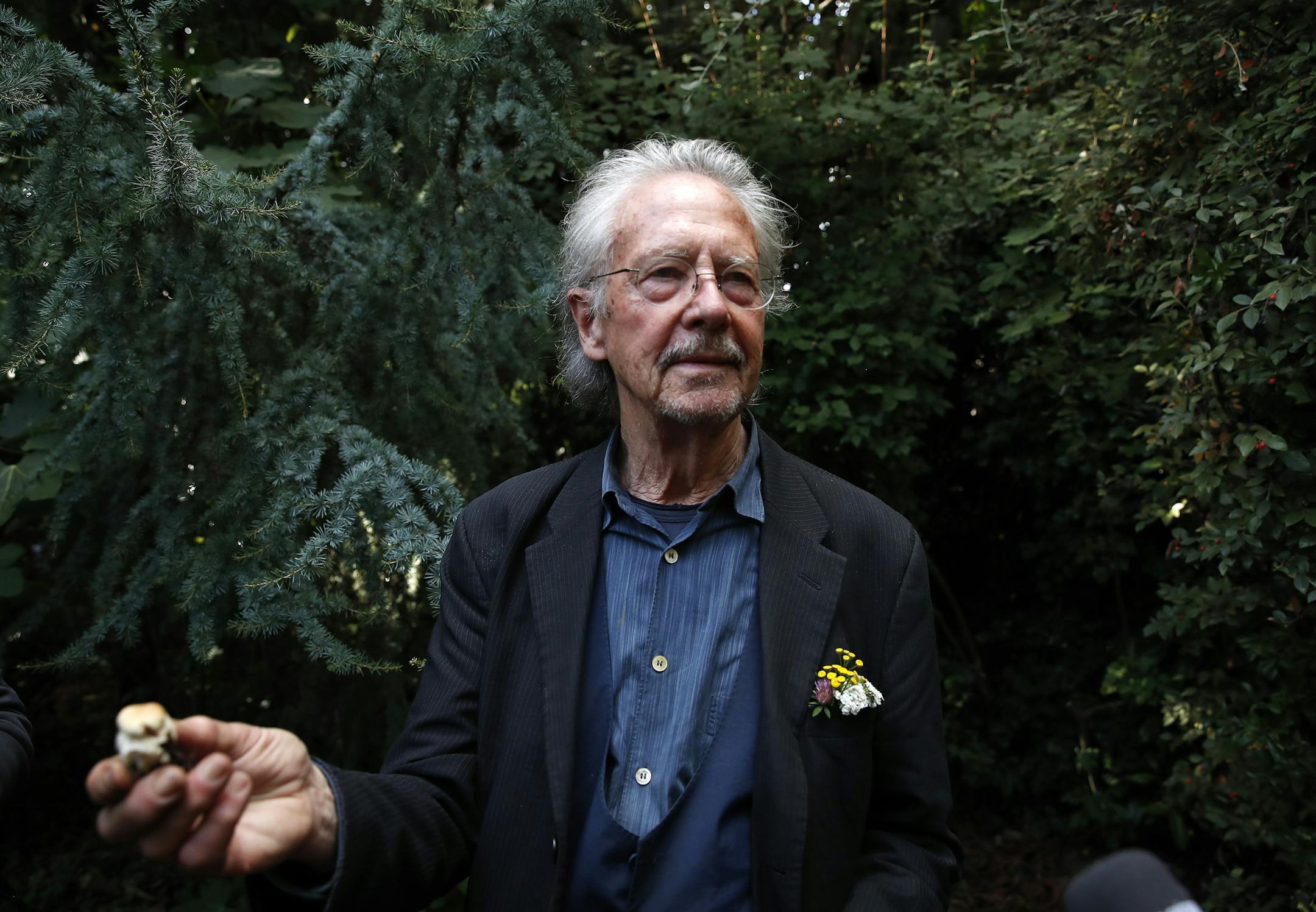 Austrian author Peter Handke holds a mushroom that he picked during a walk near his house as he poses for a photo in Chaville near Paris, Thursday, Oct. 10, 2019. Handke was awarded the 2019 Nobel Prize in literature earlier Thursday. (AP Photo/Francois Mori)