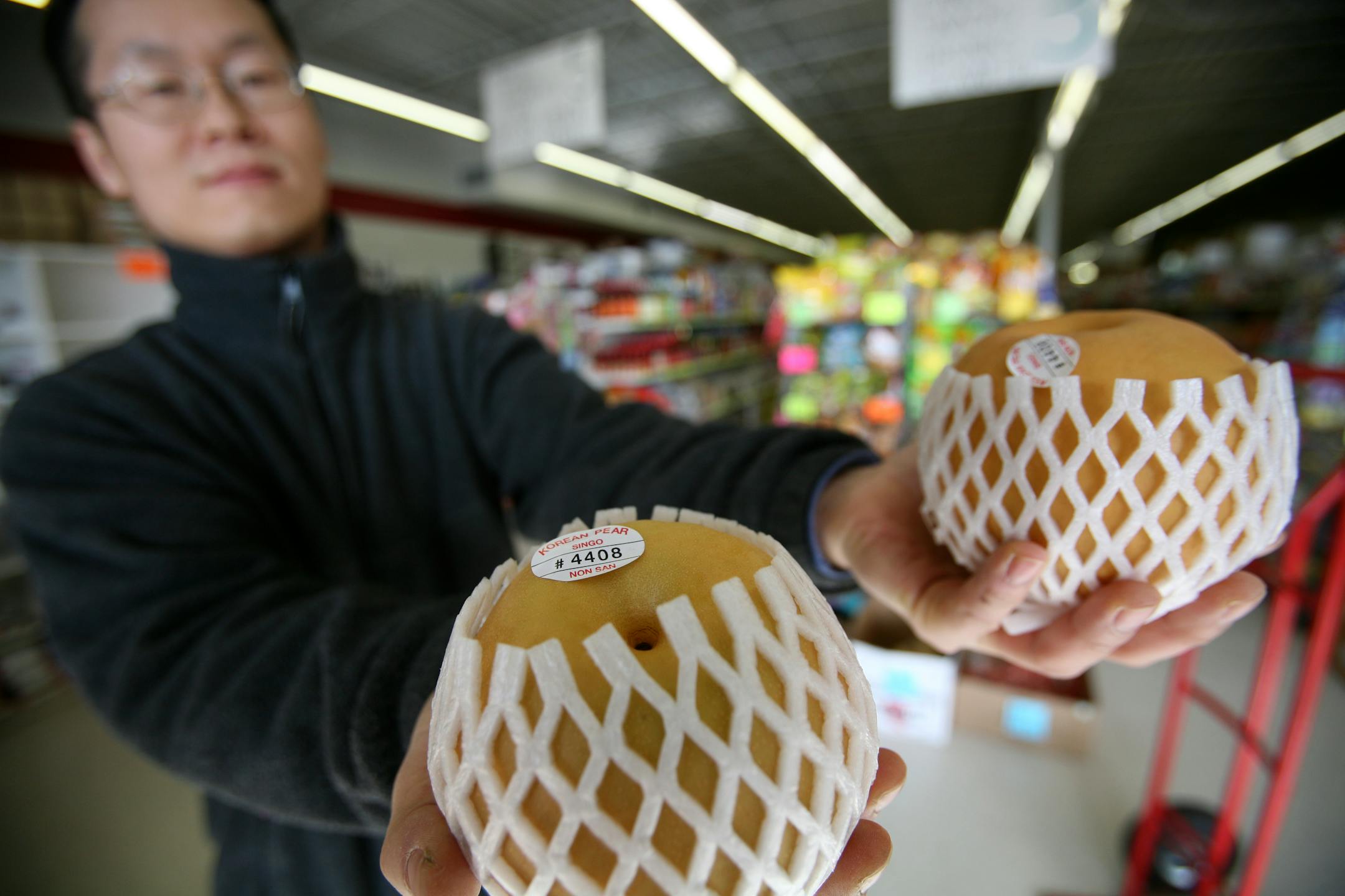 Owner Kyung Min Ahn at Seoul Foods in Fridley shows off a speciality: Fresh Korean pears, which are crunchier and juicier than the North American varieties.
