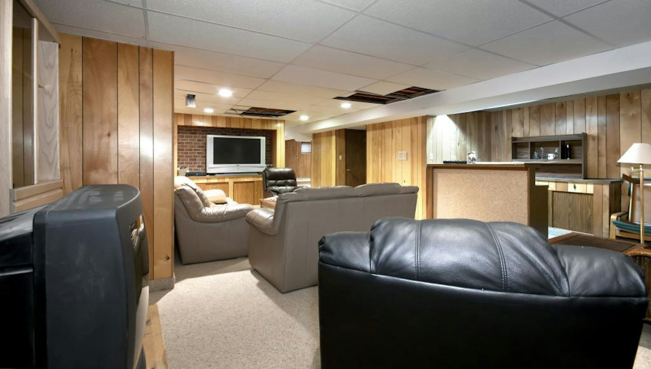 Before: With a sagging drop ceiling, harsh fluorescent lighting and thin paneled walls, this room was long overdue for a makeover.