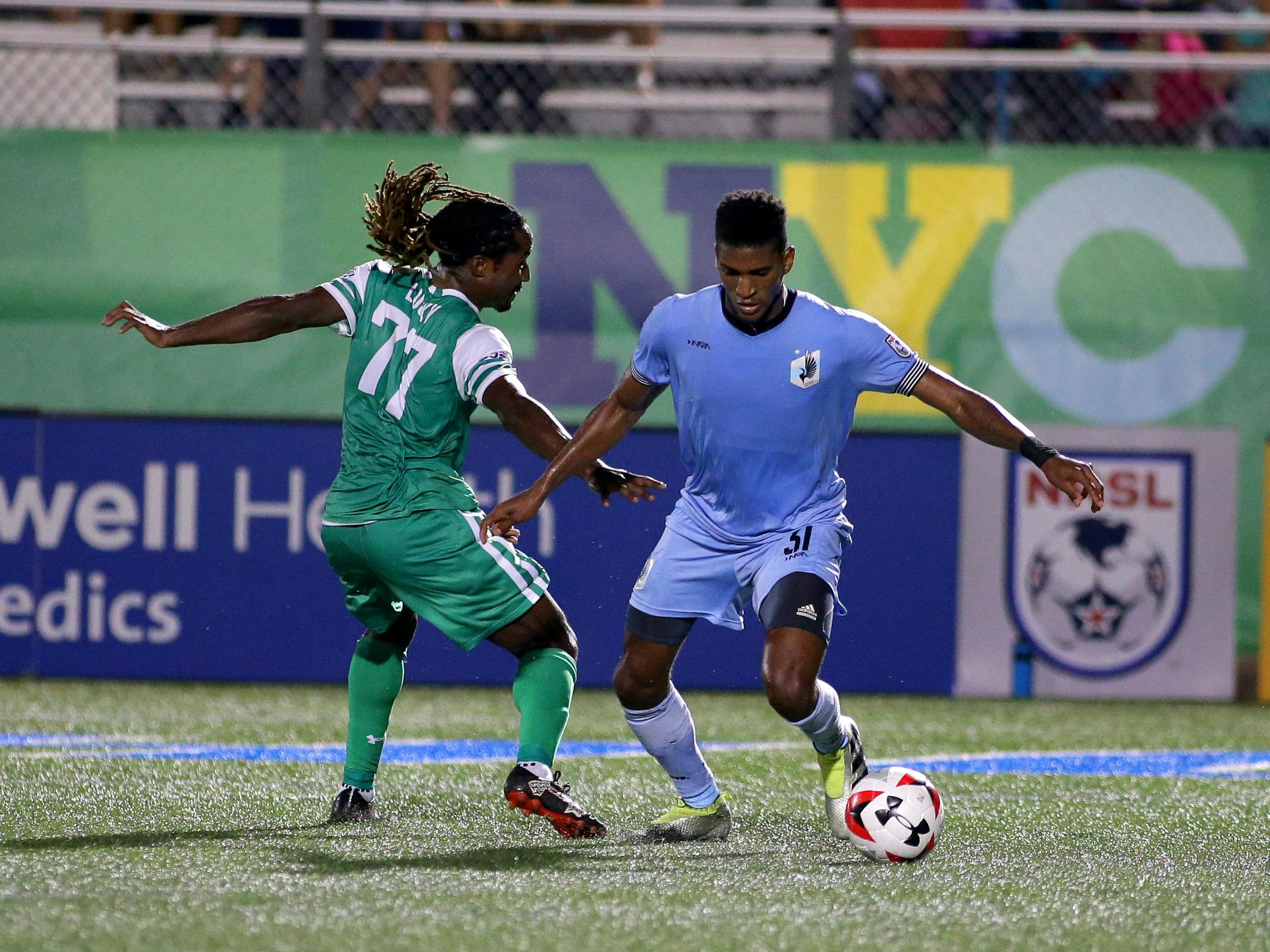 New York Cosmos forward Lucky Mkosana (77) Minnesota United FC defenseman Damion Lowe (31) battle for a loose ball during the first half at James M. Shuart Stadium.