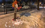 Photo by Liz Sawyer: Candles burned in the snow near the spot where a St. Paul man was fatally shot early Wednesday.