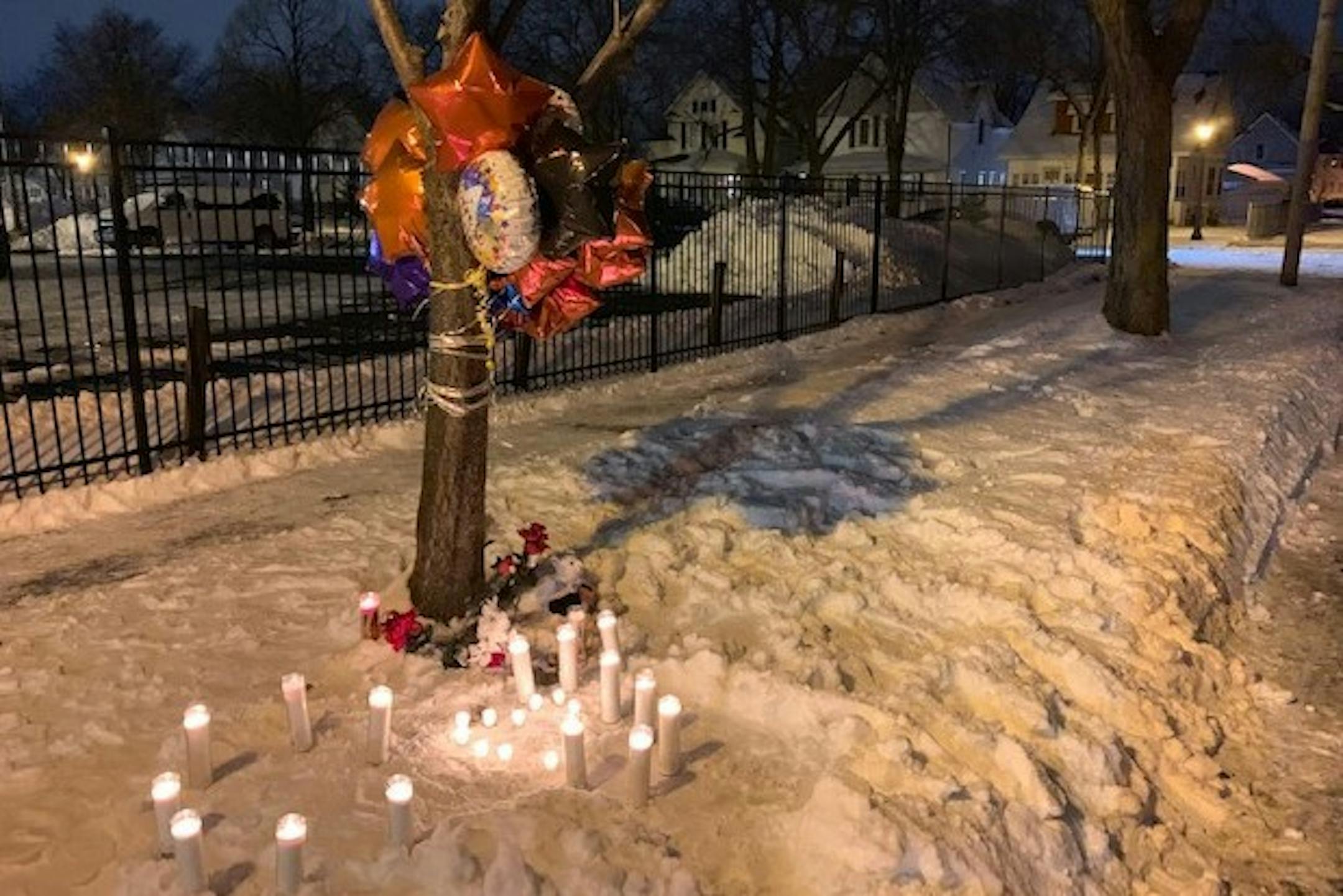 Photo by Liz Sawyer: Candles burned in the snow near the spot where a St. Paul man was fatally shot early Wednesday.
