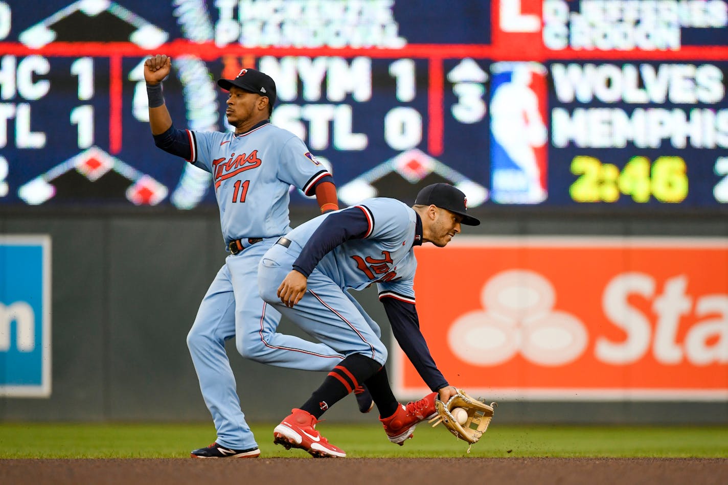 Minnesota Twins shortstop Carlos Correa, right, catches a ground ball hit by Detroit Tigers' Javier Baez as second Twins baseman Jorge Polanco moves to avoid a collision during the fourth inning of a baseball game Tuesday, April 26, 2022, in Minneapolis. Baez was out at first. (AP Photo/Craig Lassig)