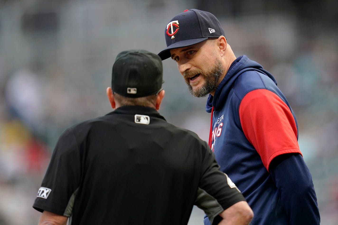 Minnesota Twins manager Rocco Baldelli, right, speaks with home plate umpire Jerry Meals, left, after an infield hit by Boston Red Sox's Tommy Pham during the first inning of a baseball game Monday, Aug. 29, 2022, in Minneapolis. (AP Photo/Abbie Parr)