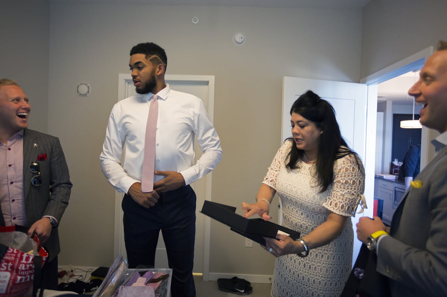 KAT's mother Jacqueline Cruz-Towns is joined by Kenny (left) and Danny King (right), owners of King Brothers Clothiers, to help style Karl-Anthony Towns in his apartment in downtown Minneapolis before his big day as NBA Rookie of the Year. ] A day in the life of Karl-Anthony Towns before and after his Rookie of the Year day.Brian.Peterson@startribune.comMinneapolis, MN - 05/16/2016