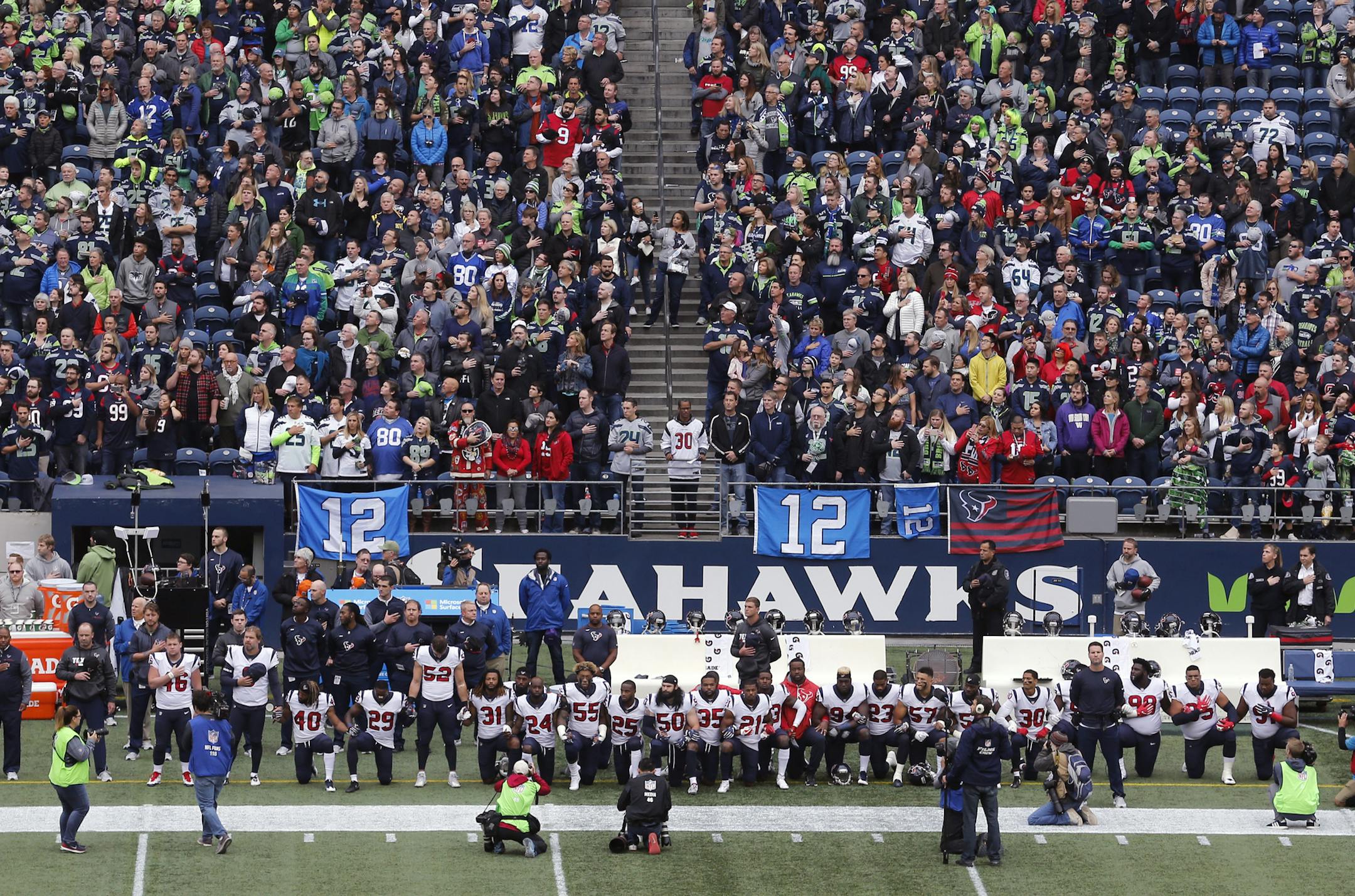 Houston Texans players kneel and stand during the singing of the national anthem before an NFL football game against the Seattle Seahawks, Sunday, Oct. 29, 2017, in Seattle. (AP Photo/Stephen Brashear)