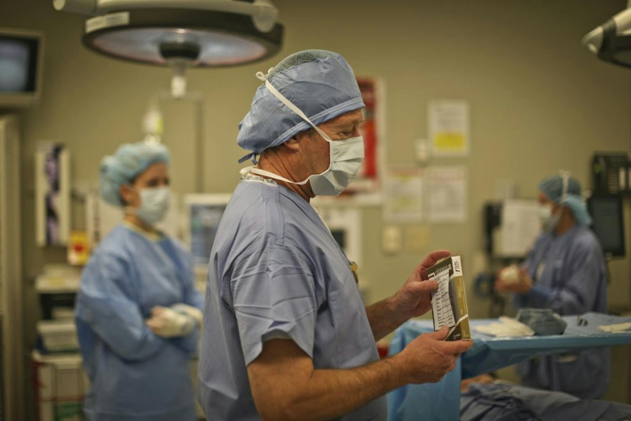 Phillips Eye Institute uses a series of protocols to actively prevent medical errors. In this picture, Dr. Jeffrey Christensen does what's called a "time out" where the surgical team meet and all double check that they have the correct materials including the intraocular lenses he is holding (there are hundreds of brands and powers of intraocular lenses), before a cateract surgery at the Phillips Eye Institute in Minneapolis, Minn. on Wednesday, January 30, 2013.