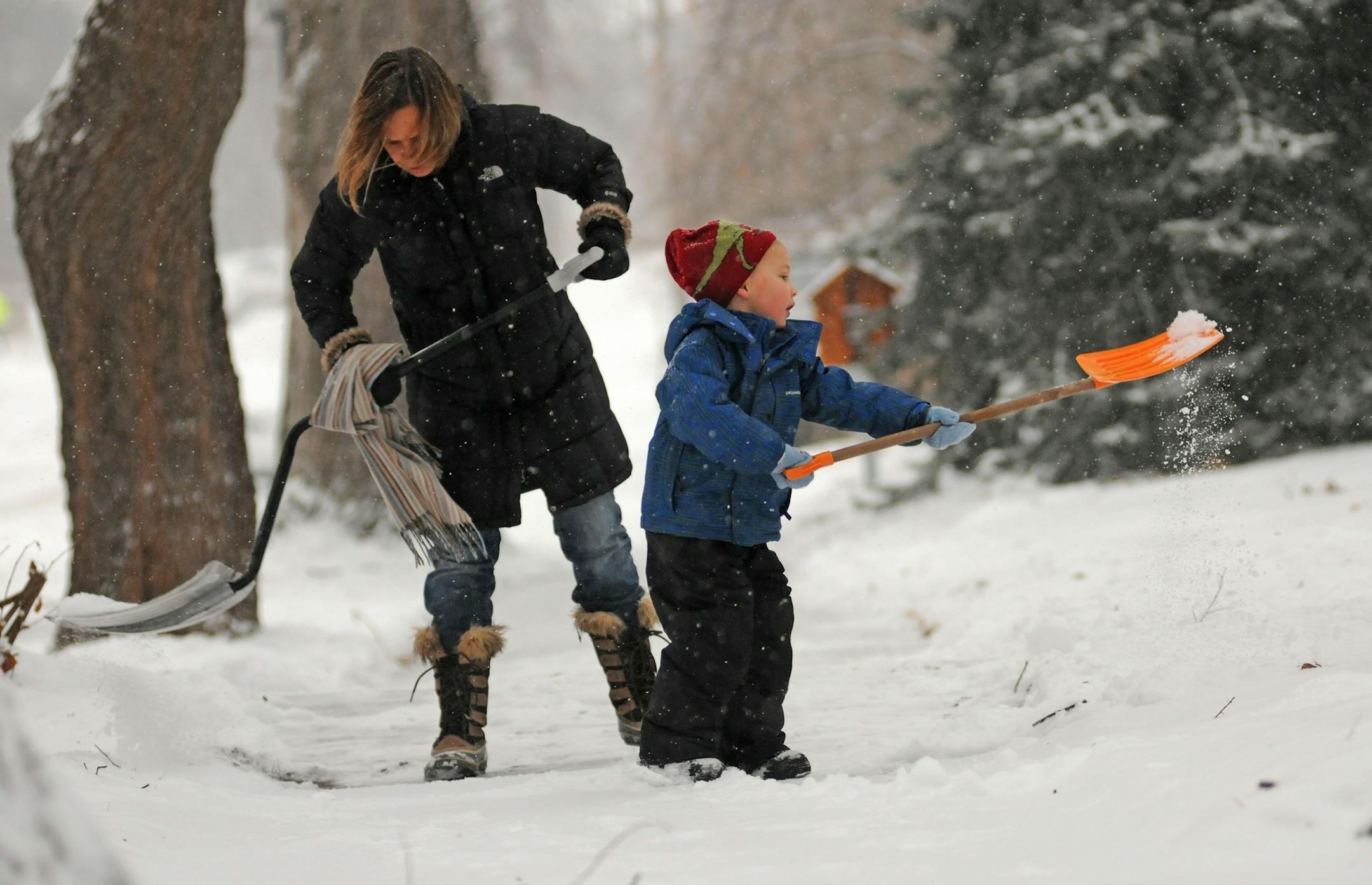 Lissa Pawlisch shoveled the sidewalk with her 4-year-old son Graham Bailey in front of their home on Emerson Ave South in Minneapolis on Monday morning January 23,2012.