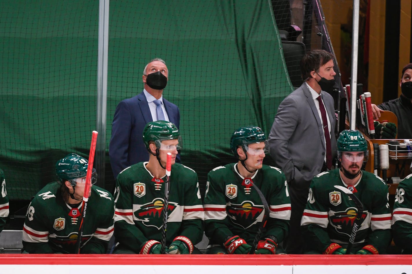 Minnesota Wild coach Dean Evason checks the scoreboard during the second period of the team's NHL hockey game against the Anaheim Ducks on Saturday, May 8, 2021, in St. Paul, Minn. The Wild won 4-3 in overtime. (AP Photo/Craig Lassig)