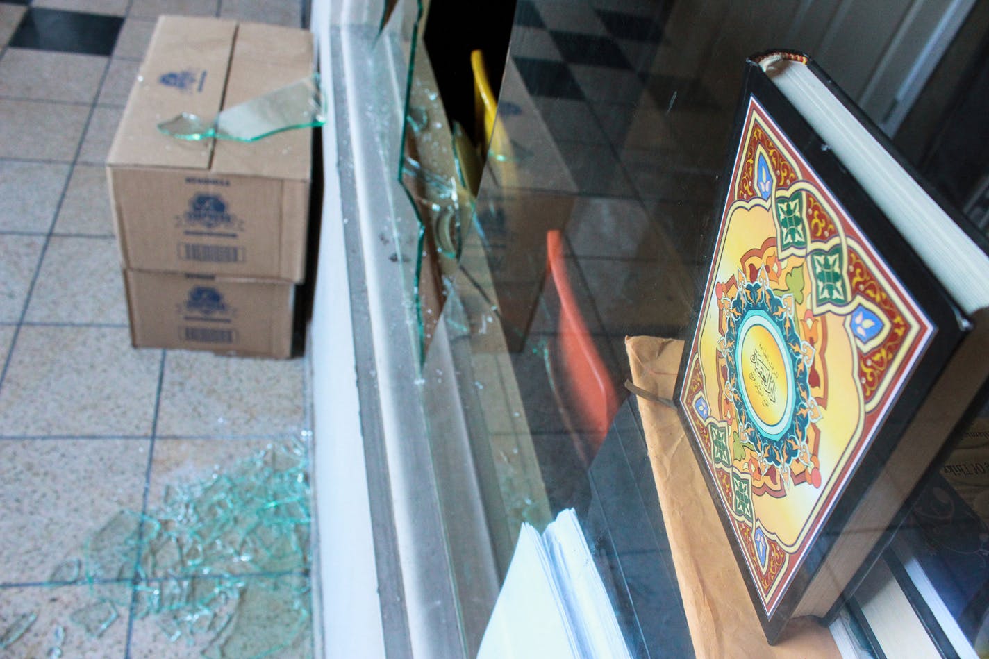 205860 1mosque - A copy of the quran is shown above the shattered glass above one of the broken windows at the south Minneapolis mosque. ] Sophie Hoover Star Tribune Intern