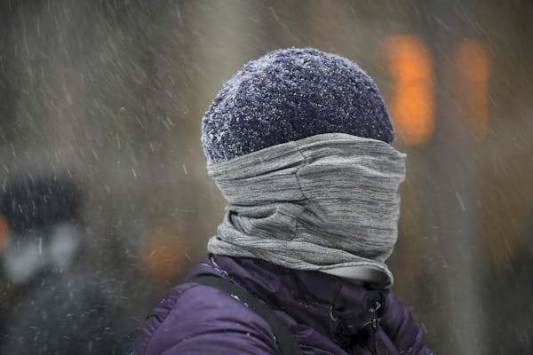 Tamara Tureson, of Maple Grove, was all bundled up as she waited Thursday for her bus in downtown Minneapolis. As the snow moved out, bitter cold was 