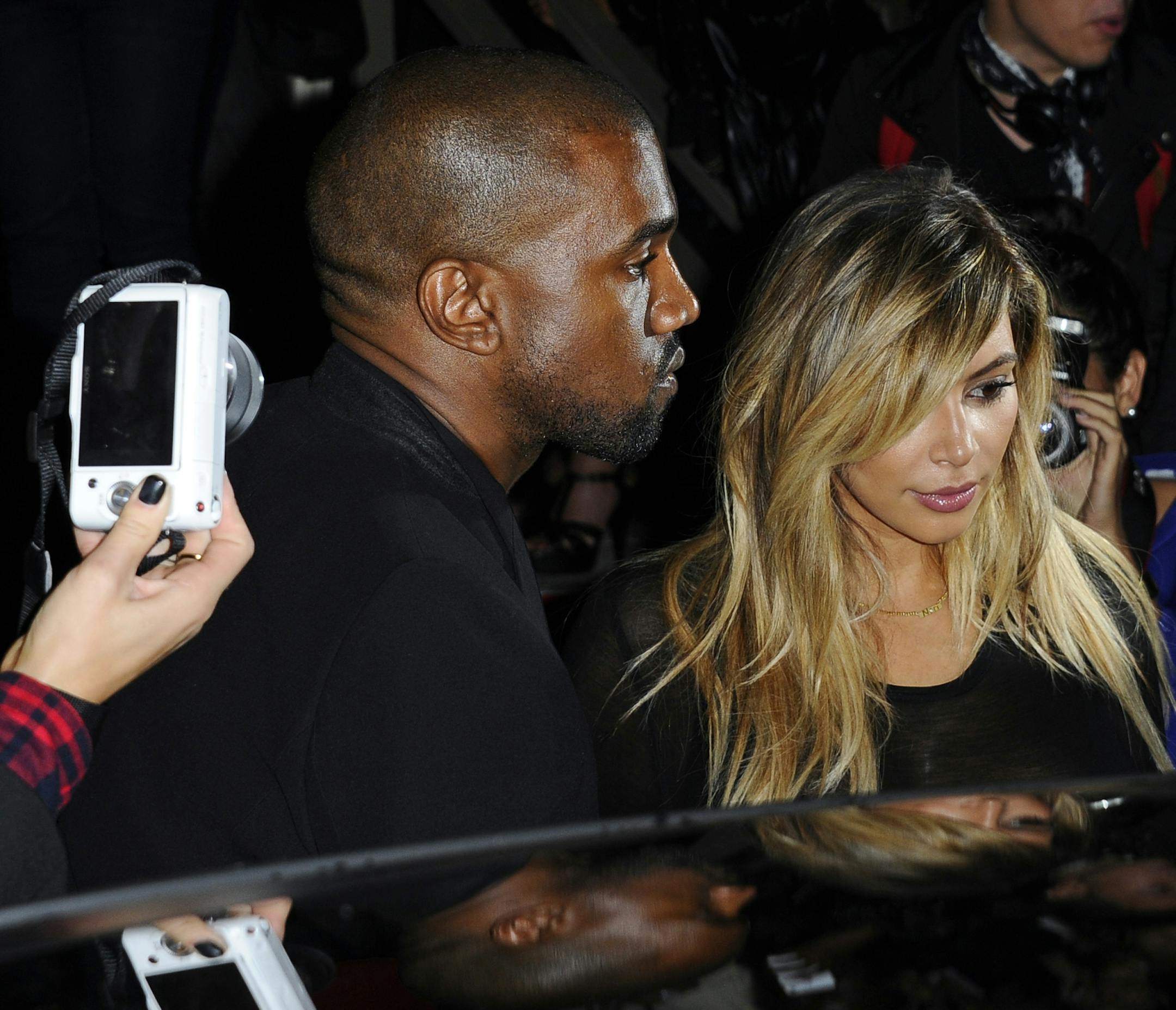 FILE - In this Sept. 29, 2013 file photo, Kanye West, left, and Kim Kardashian leave after attending Givenchy's ready-to-wear Spring/Summer 2014 fashion collection in Paris. (AP Photo/Zacharie Scheurer, File)