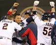 Minnesota Twins third baseman Miguel Sano (22) was mobbed by teammates after hitting a single in the ninth inning scoring Brian Dozer for a 6-5 win at