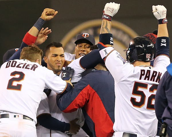 Minnesota Twins third baseman Miguel Sano (22) was mobbed by teammates after hitting a single in the ninth inning scoring Brian Dozer for a 6-5 win at