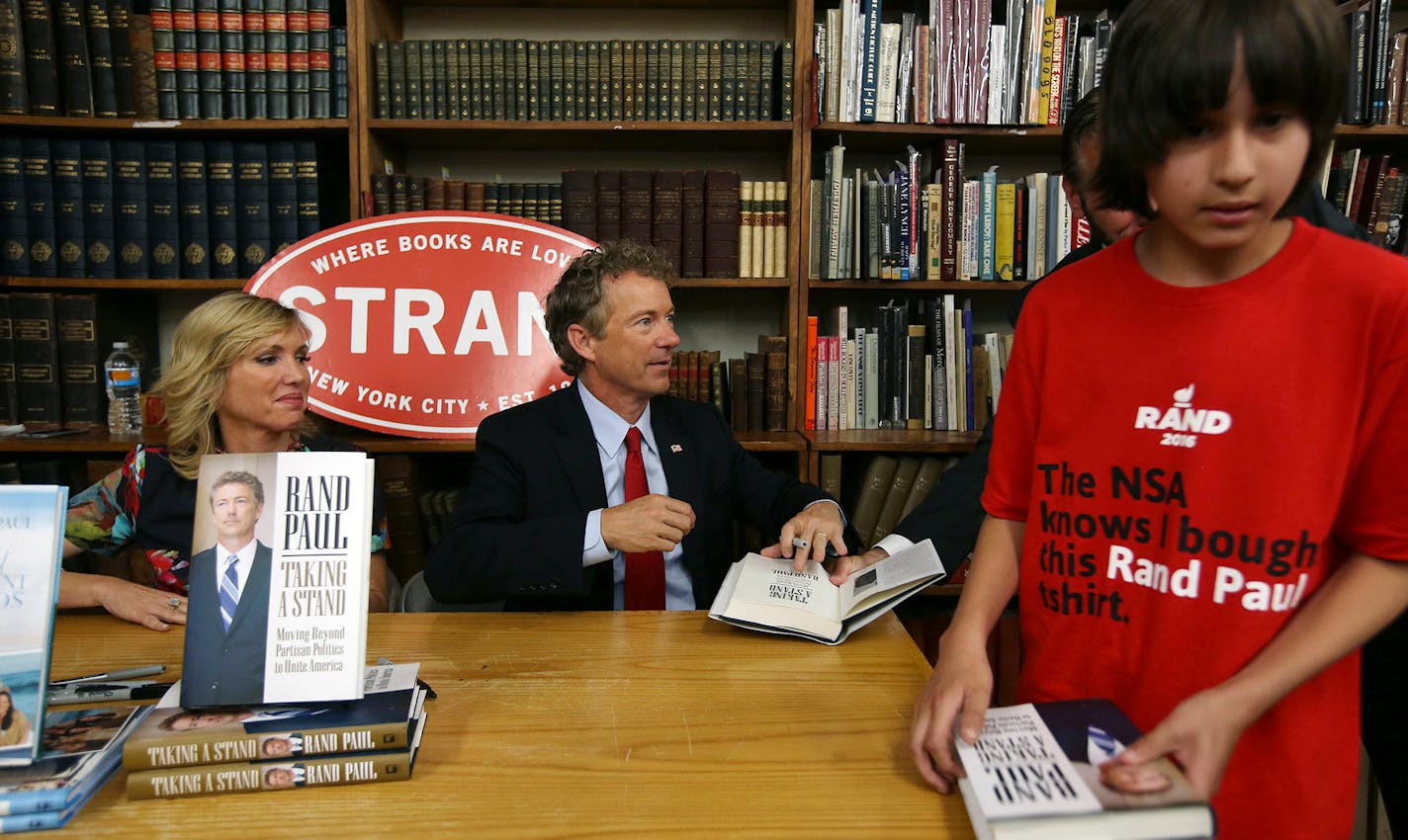 Sen. Rand Paul, R-Ky., a presidential candidate, signed his book "Taking a Stand: Moving Beyond Partisan Politics to Unite America" in New York on May 26. Paul's wife, Kelley Paul is at left. Paul has tried to take his libertarian message to places Republicans don't usually campaign.