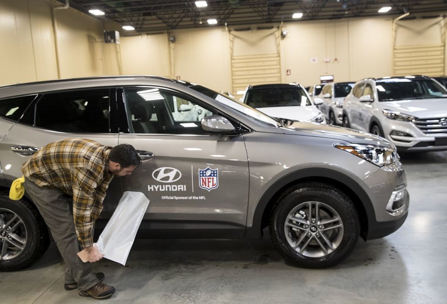 Dan Winters put a decal on a Hyundai Santa Fe Sport at the Hyundai storage location at Canterbury Park for the 400 Super Bowl cars for Super Bowl executives, traveling workers and the teams on Tuesday, December 19, 2017, in Shakopee, Minn. Hyundai if the NFL's official car sponsor.