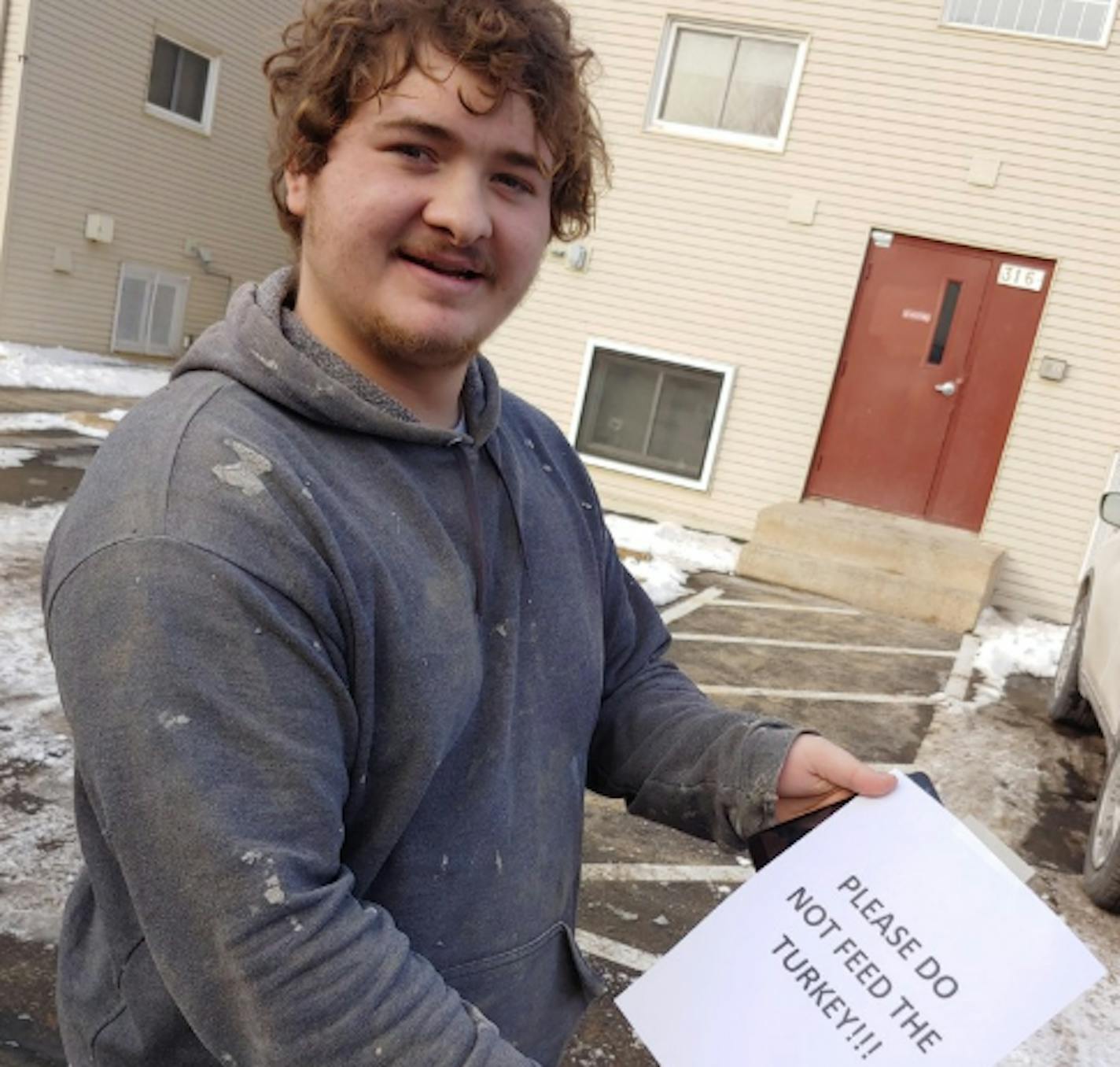 St. Paul Park resident Andrew Jerome Placzek shows the sign that his landlord hung at an apartment complex after a turkey began hanging out in the parking lot.