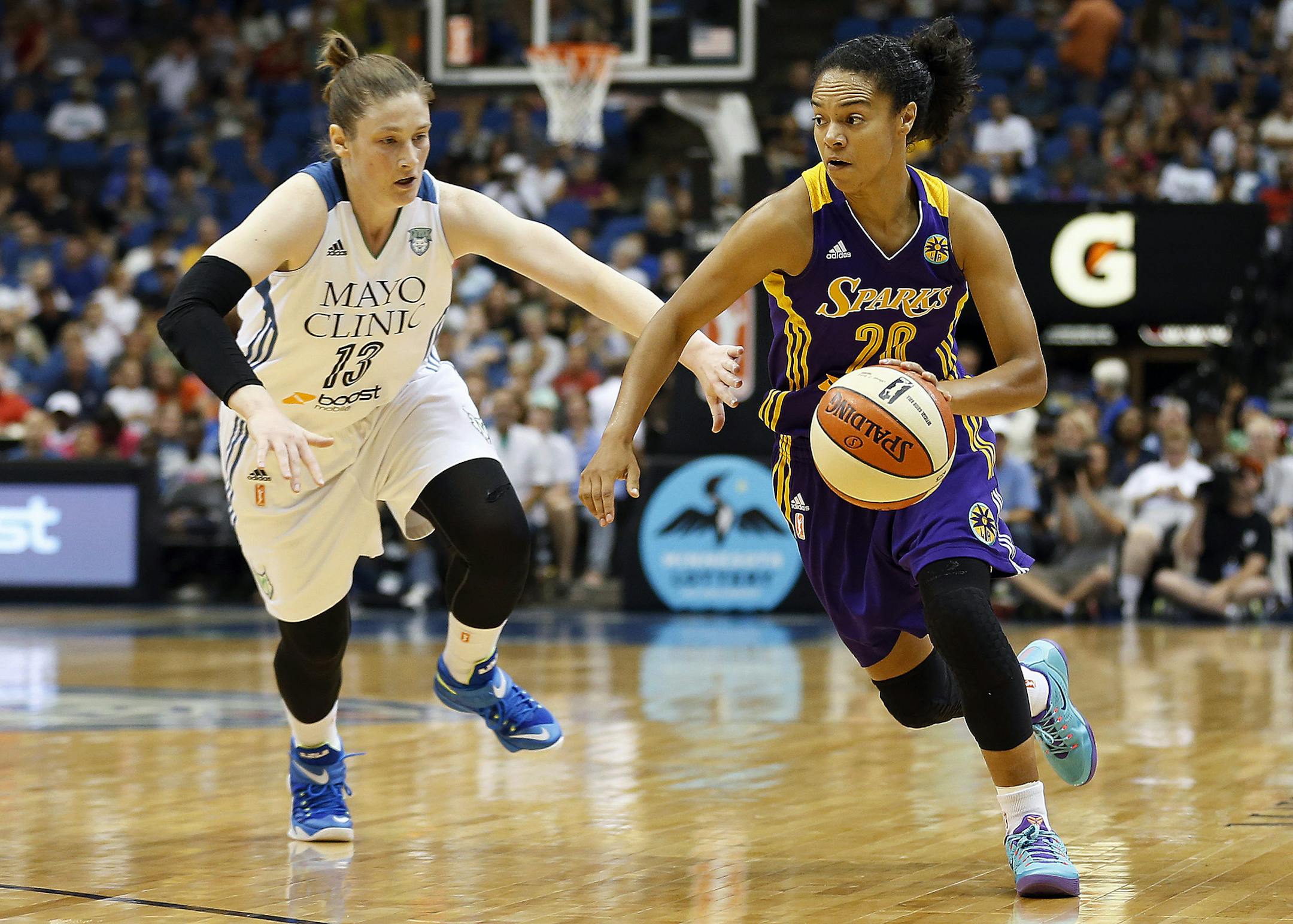 Los Angeles Sparks guard Kristi Toliver (20) pushes the ball down the court against Minnesota Lynx guard Lindsay Whalen (13) in the first half of a WNBA basketball game, Tuesday, Aug. 12, 2014, in Minneapolis. (AP Photo/Stacy Bengs)