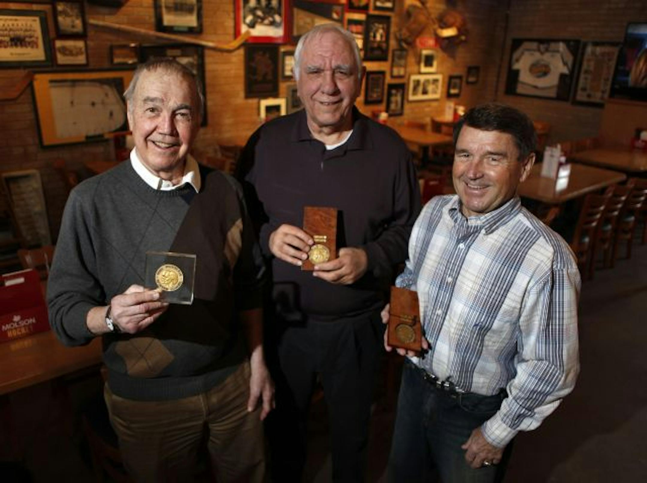 Paul Johnson, left, Jack McCartan, center, and Dick Meredith held their 1960 Olympic hockey gold medals.