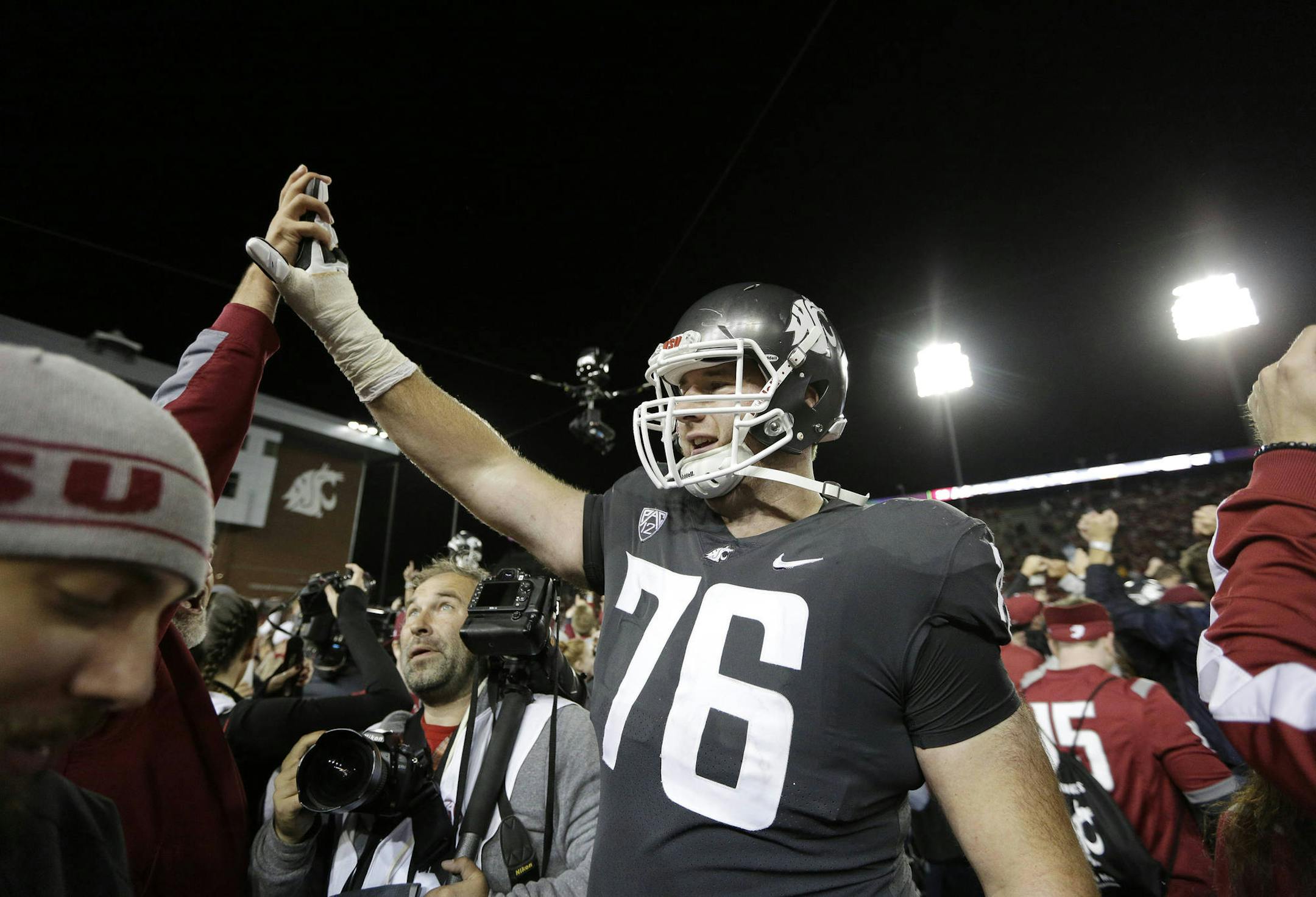 Washington State offensive lineman Cody O'Connell (76) celebrates with fans after his team won an NCAA college football game against Southern California in Pullman, Wash., Friday, Sept. 29, 2017. (AP Photo/Young Kwak)