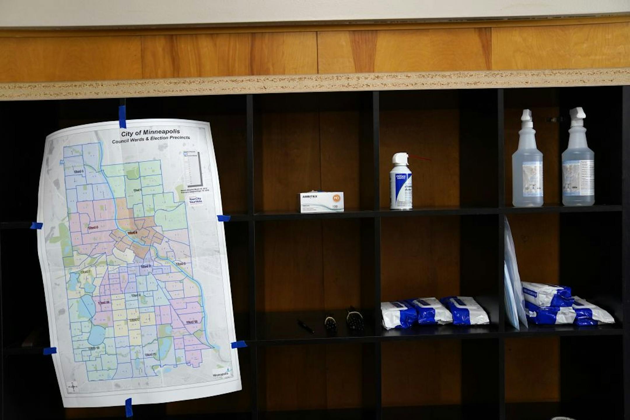 An election ward map sat taped on cubby of hand sanitizer and disinfecting wipes as voters arrived to cast their ballots Tuesday morning at Northeast Middle School in Minneapolis.