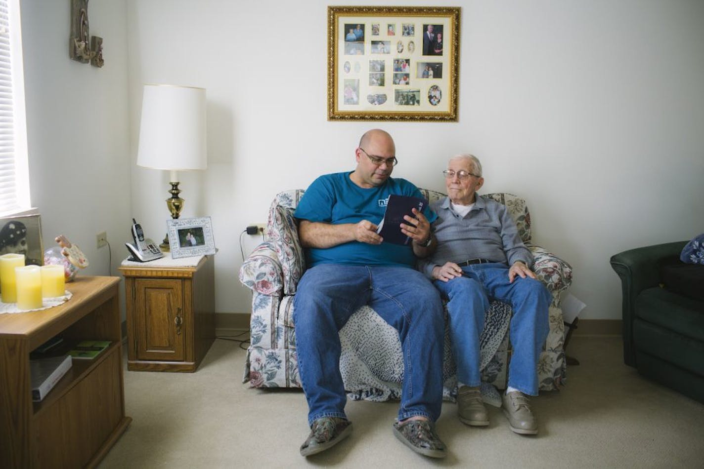 Gayle Snyder, 95, right, looks through his photo albums with his home caregiver Jeffrey Interiano in Zion, Ill., Oct. 22, 2015. While it is far preferable for retirees to remain at home as they age, the choices and costs can be daunting.